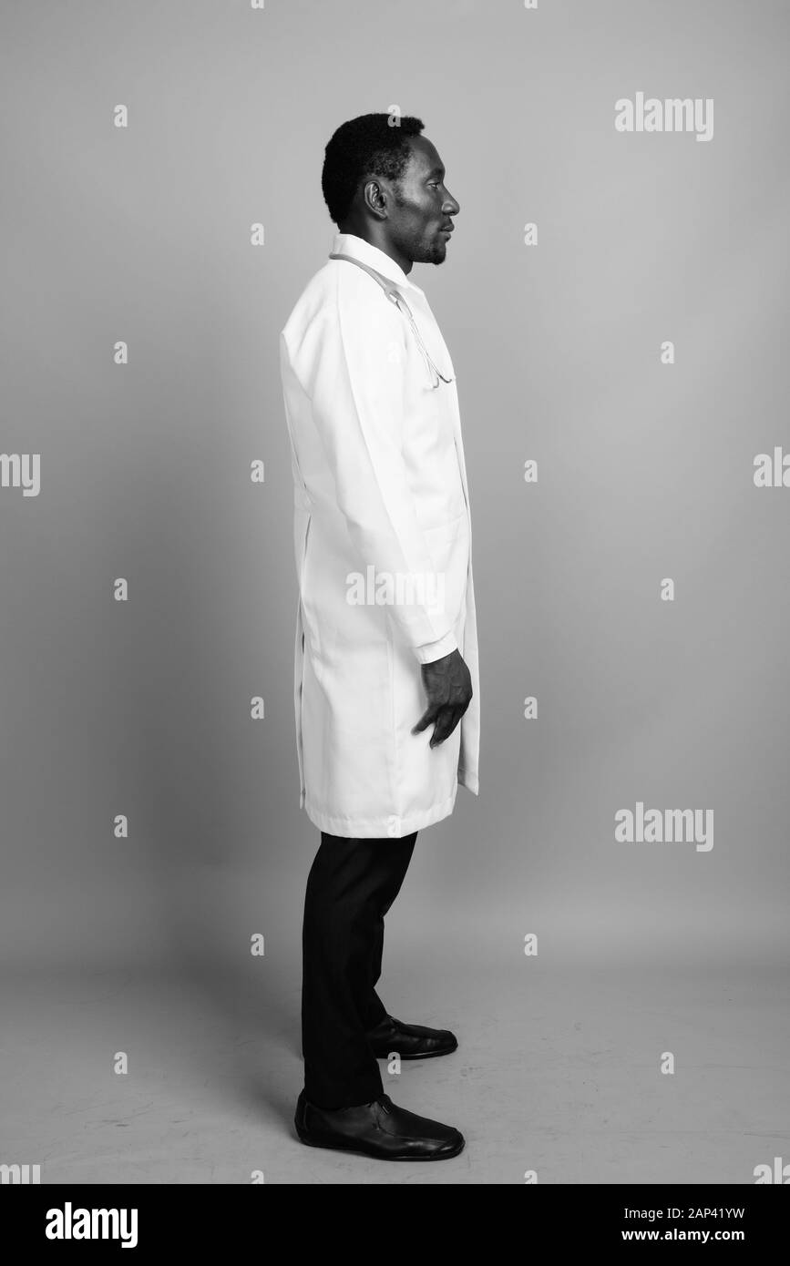Bel giovane uomo africano medico contro uno sfondo grigio Foto Stock