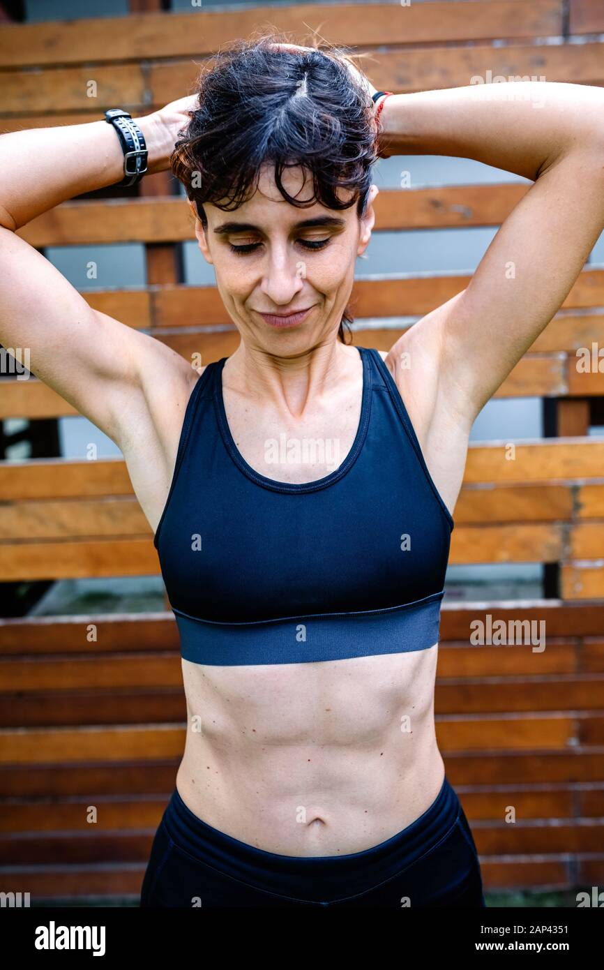 Sportswoman dopo l'allenamento di fronte ad uno sfondo di legno Foto Stock