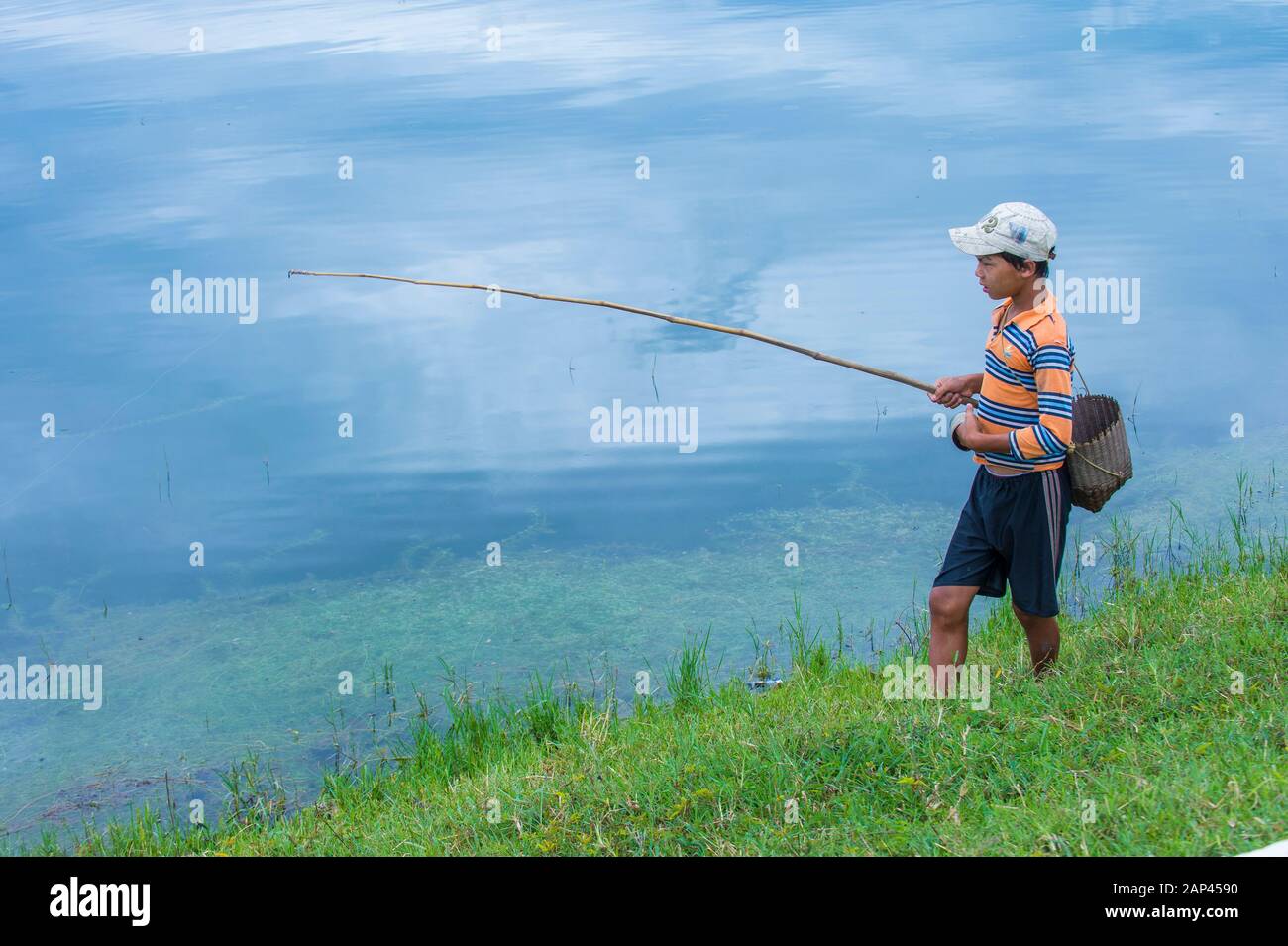 Ragazzo birmano pesca in un villaggio vicino al lago Inle Myanmar Foto Stock