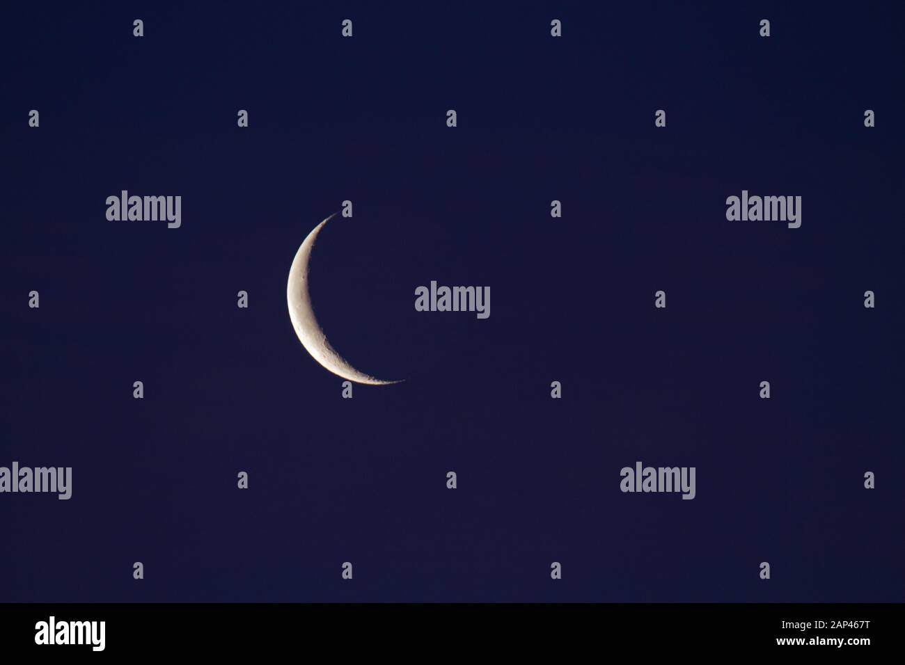 Luna crescente in declino nel cielo blu scuro Foto Stock