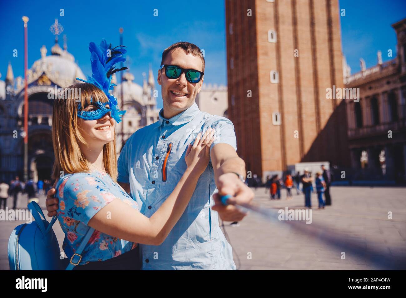 Amante Selfie giovane prendendo foto di viaggio Venezia, Italia contro sfondo San Marco in blu maschera veneziana Foto Stock