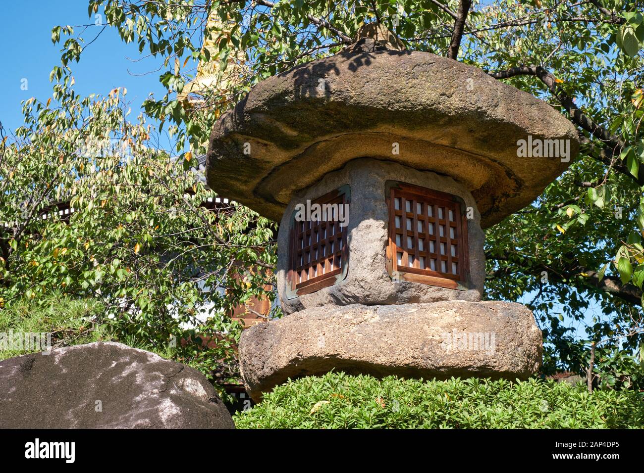 La vista della lanterna di pietra giapponese Nazura-doro fatta con pietre ruvide e non lucidate nel Tempio Isshin-ji di Osaka. Giappone Foto Stock