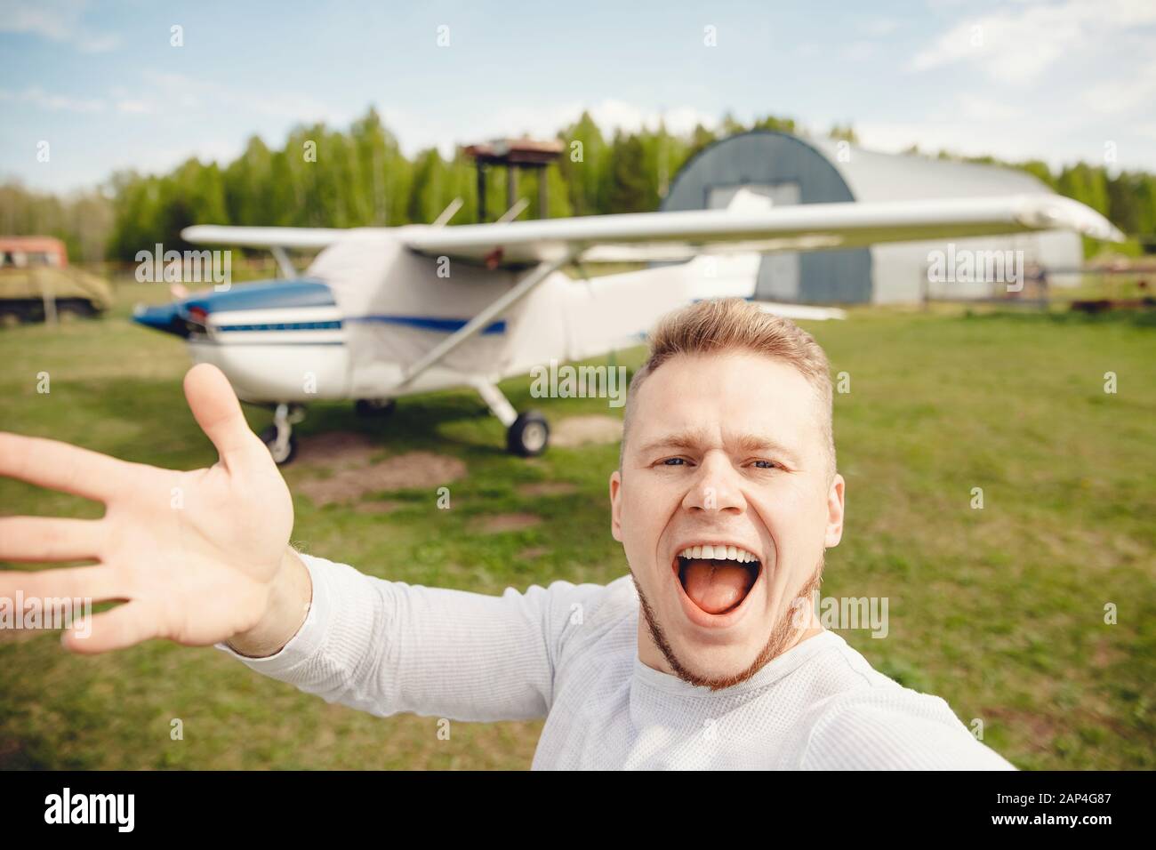 Pilota uomo scattare foto selfie su piano di sfondo, sorridendo felicemente Foto Stock