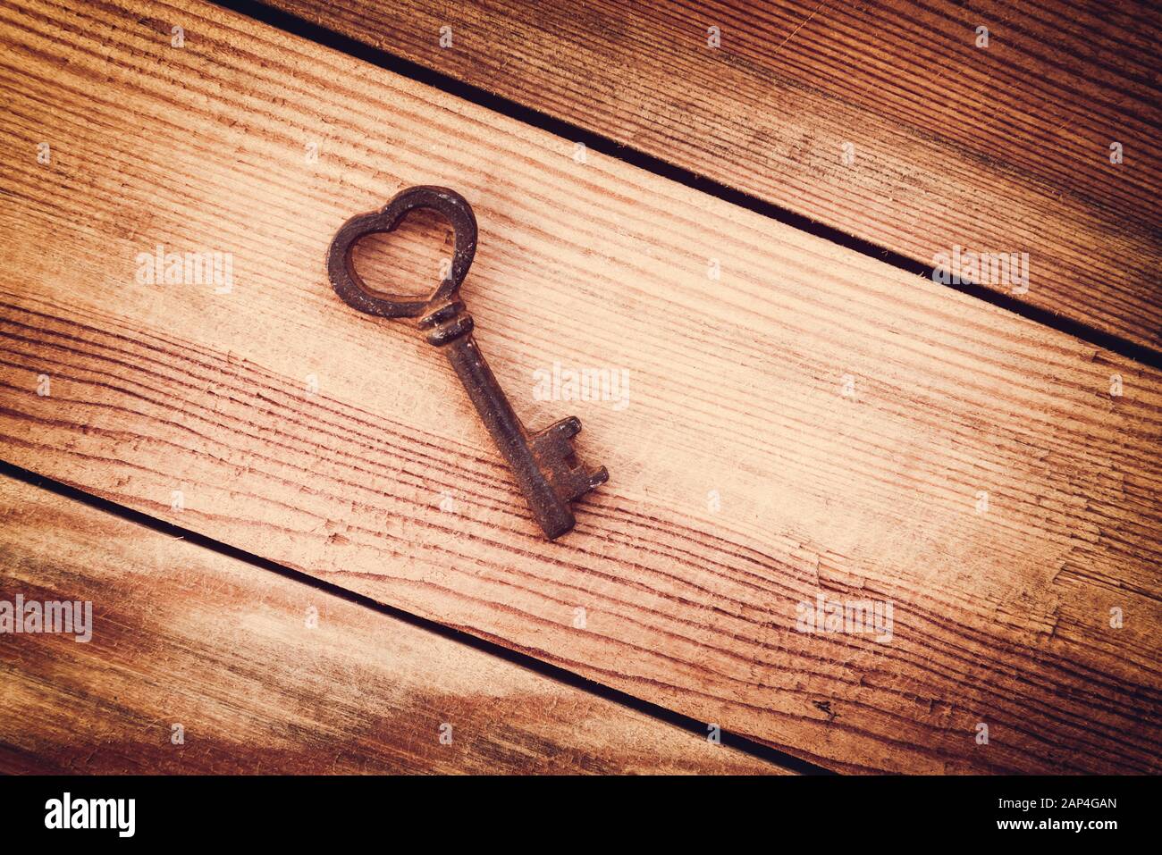Vecchio arrugginito chiave vintage a forma di cuore, uno sfondo di legno. Amore e il giorno di San Valentino biglietto di auguri Foto Stock