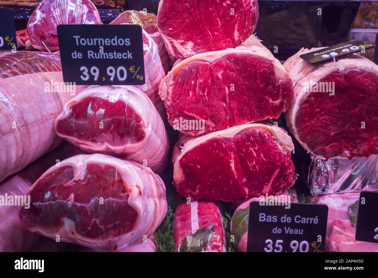 Display rosso di carni bovine sul display in un tradizionale francese Butcher Shop. Le etichette con i prezzi in euro. Foto Stock