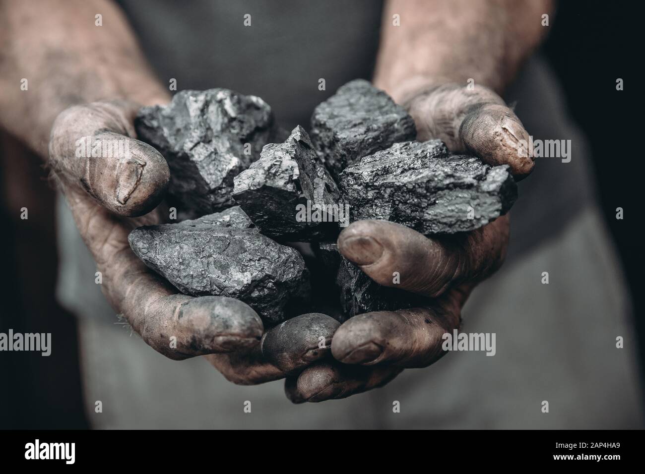 Minatore mani sporche tenere carbone. Industria mineraria di concetto Foto Stock