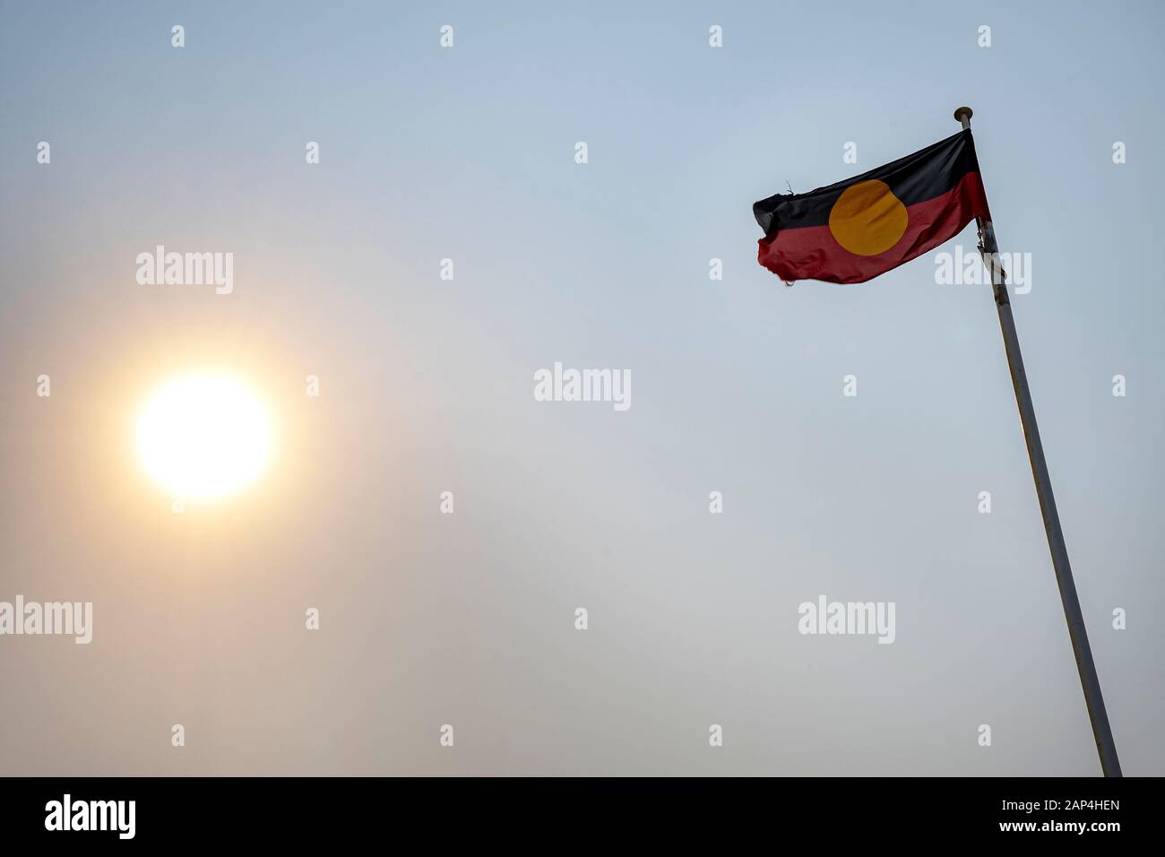 Aborigeni battenti bandiera contro sky con bassa sun Foto Stock
