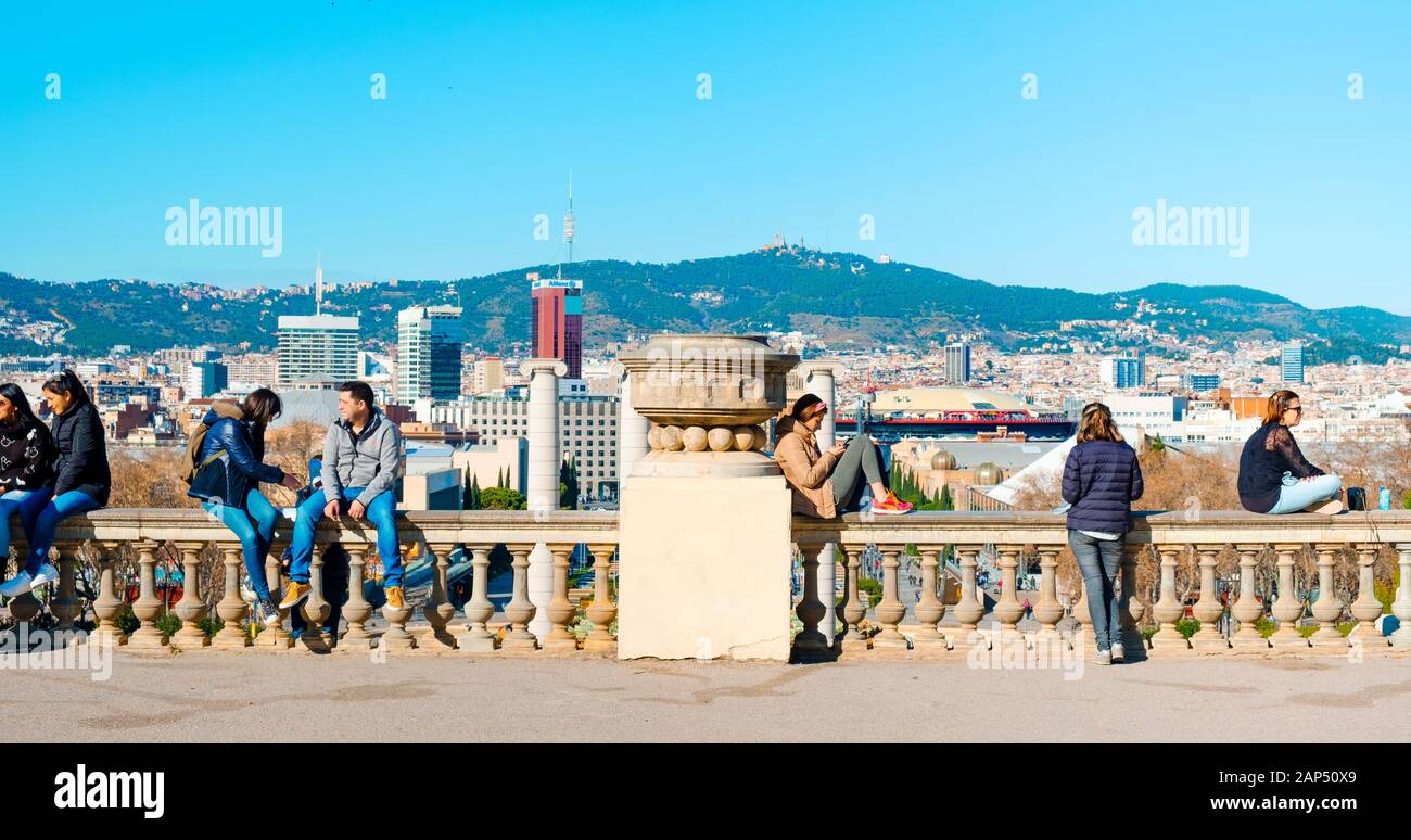 Barcellona, Spagna - 18 gennaio 2020: persone appese alla sommità del Montjuic Hil a Barcellona, Spagna, con la città al di sotto di esse e la collina di Tibidabo Foto Stock