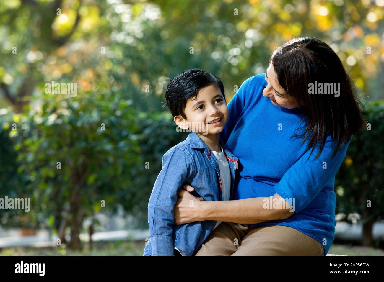 Nonna amorevole che abbraccia suo nipote al parco Foto Stock