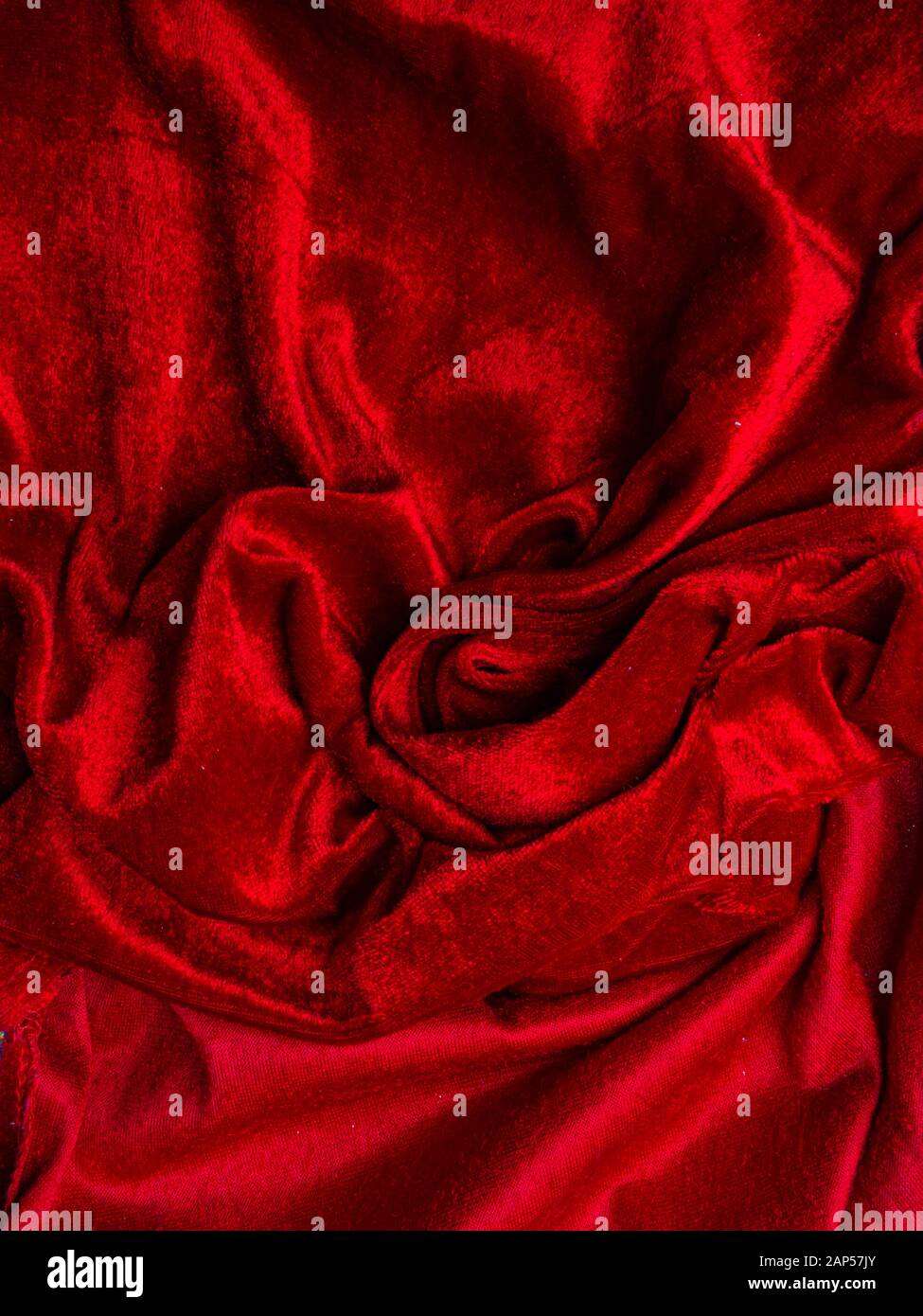 In velluto rosso scuro per la texture di sfondo, red rose forma, amore e passione concetto. Molto affettuoso e appassionato. Foto Stock