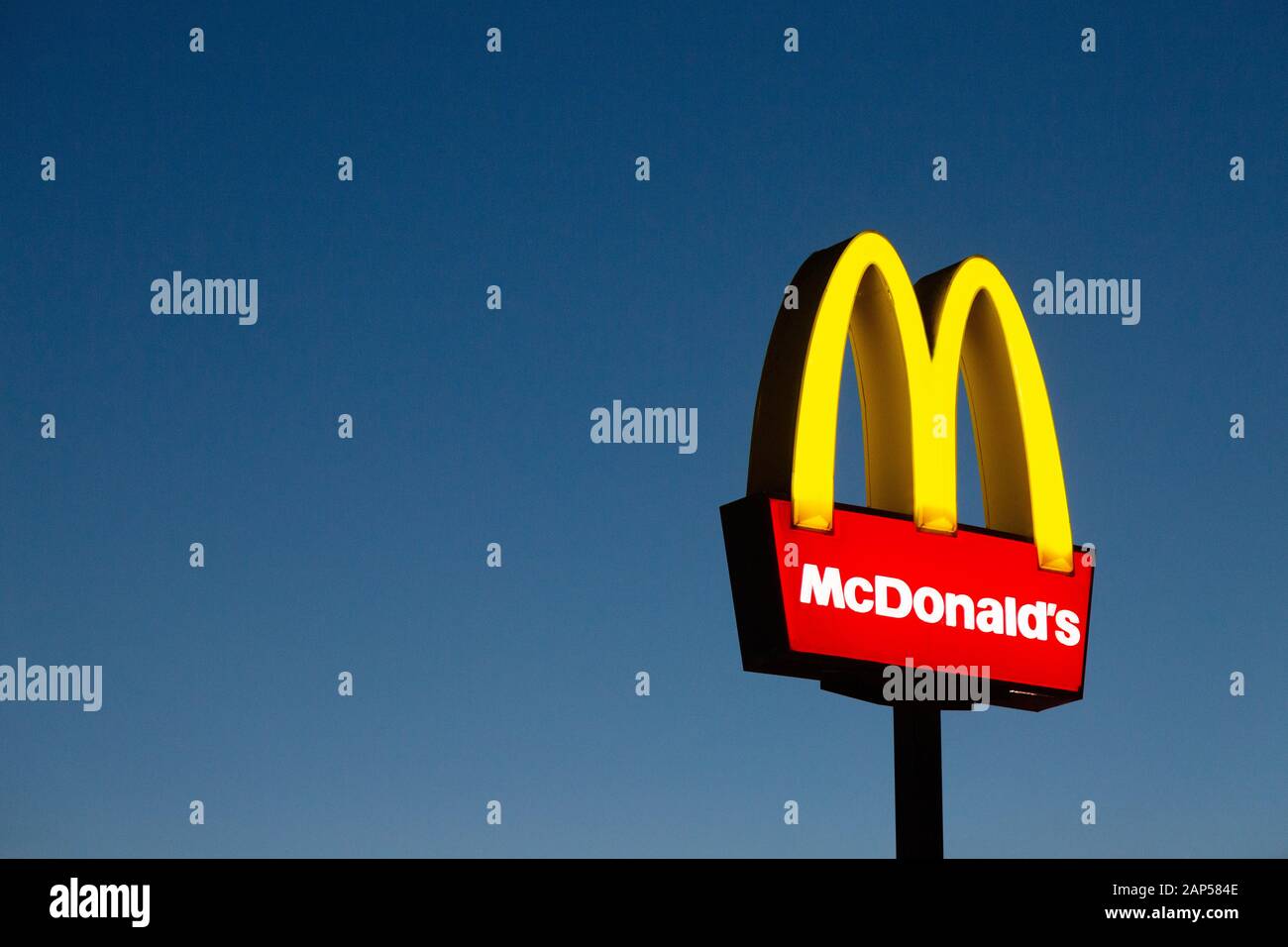 McDonalds segno o logo, illuminato contro un cielo blu scuro al crepuscolo, Lincolnshire Regno Unito Foto Stock