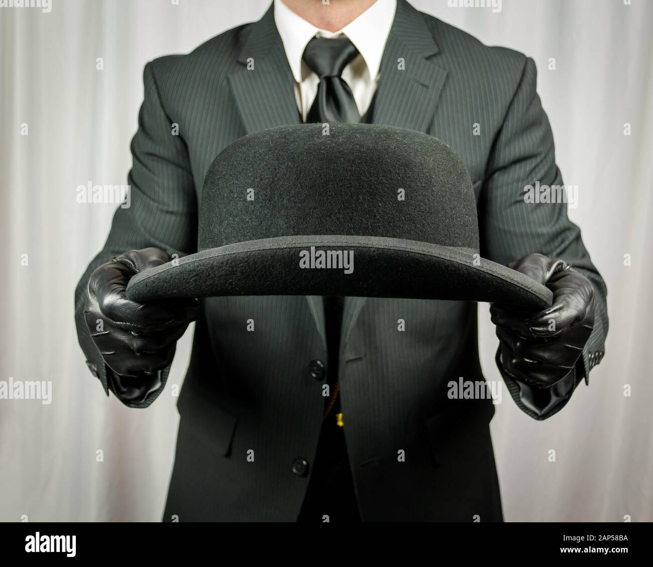 Cappello Bowler di Holding del maggiordomo britannico. Concetto di inglese  classico ed eccentrico Gentleman. Moda retrò Foto stock - Alamy