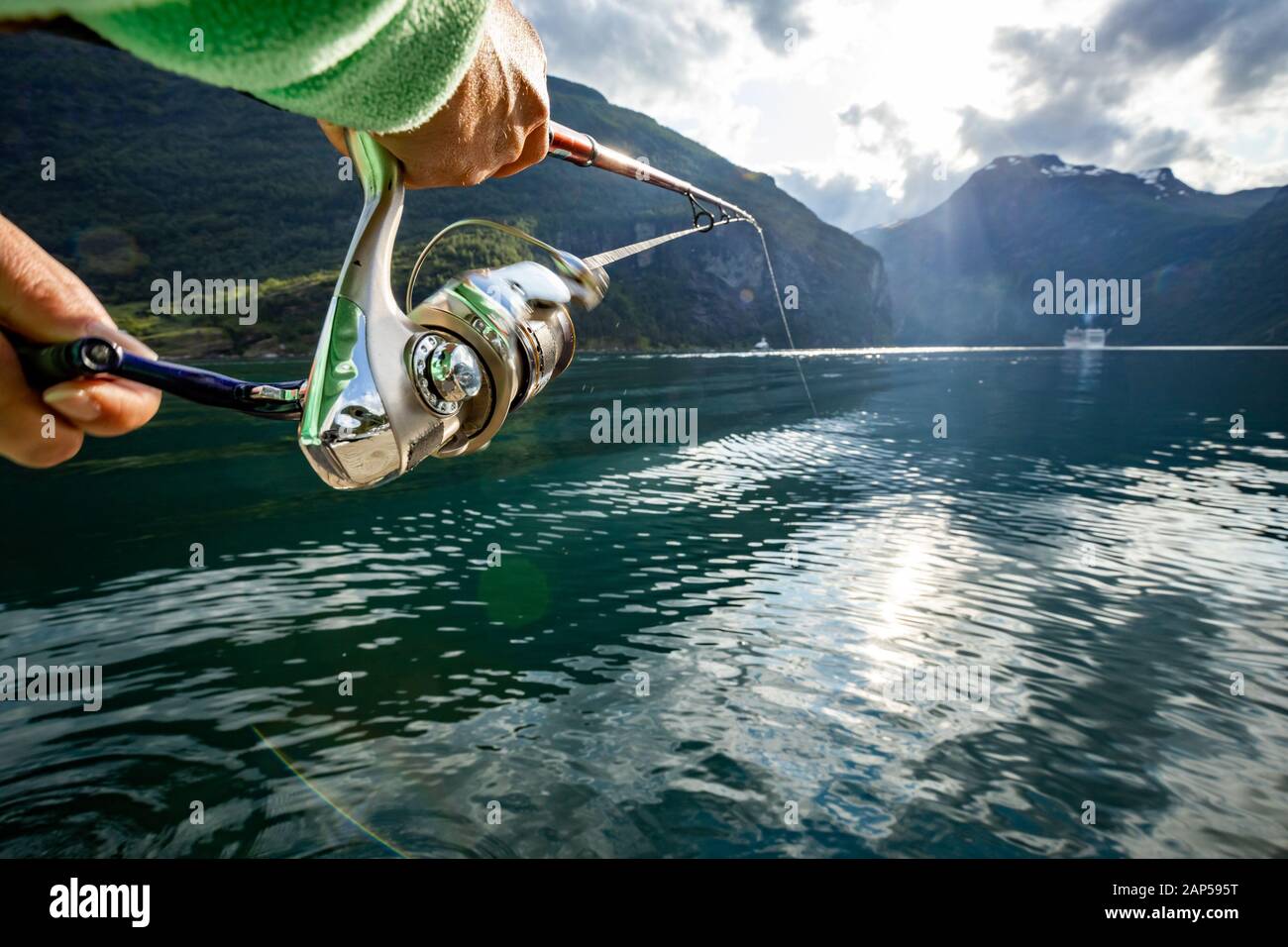 La donna la pesca sulla canna da pesca la filatura in Norvegia. La pesca in Norvegia è un modo per abbracciare lo stile di vita locale. Innumerevoli laghi e fiumi e un extensiv Foto Stock