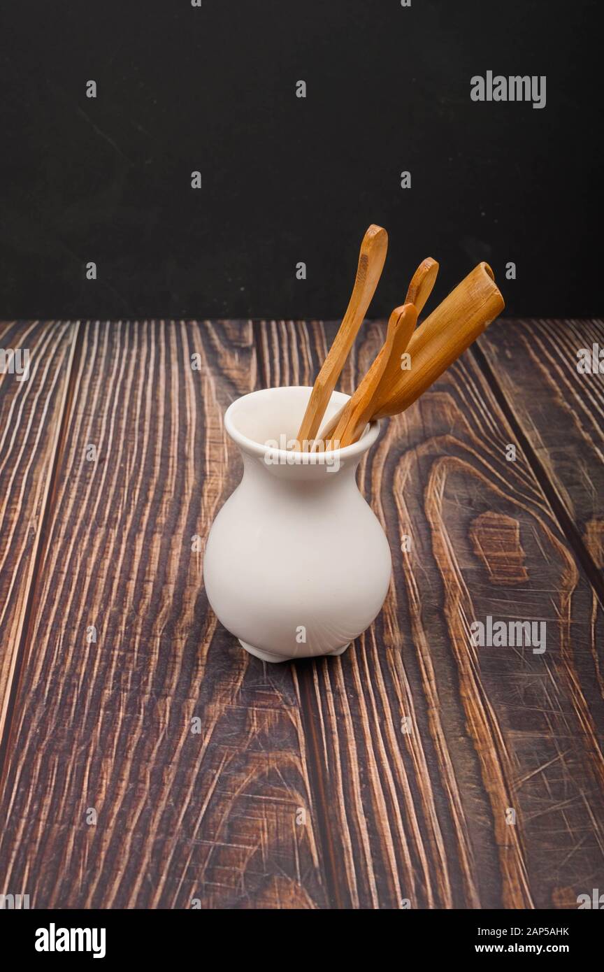 Dispositivi per il tradizionale tè cinese bevendo di bambù in un vaso in ceramica bianca in stile cinese su uno sfondo di legno. Primo piano Foto Stock