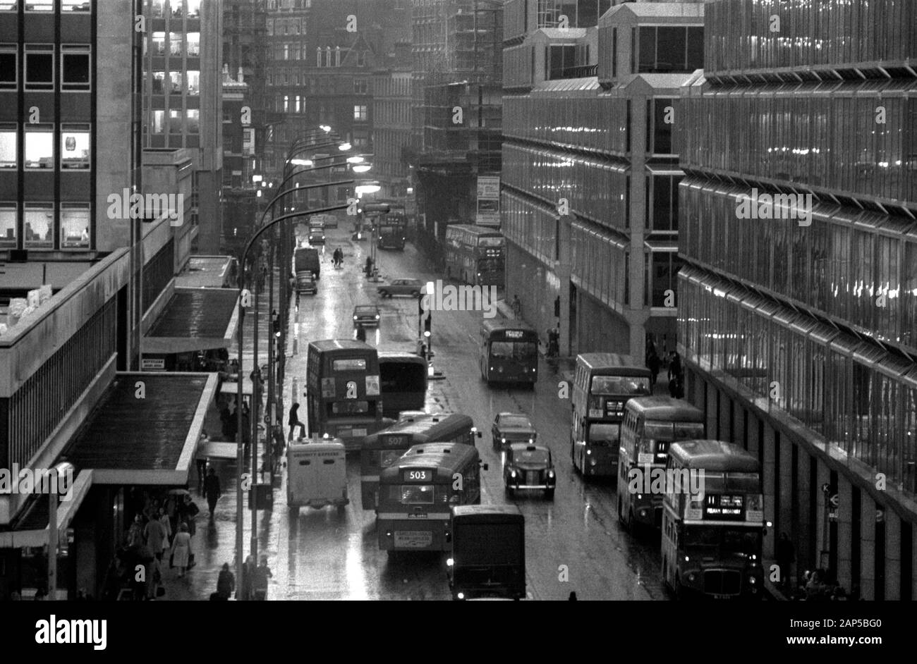 London 1970s Victoria Street. Ora di punta serale, persone, taxi, auto e autobus scuri e bagnati come pendolari fare il loro modo di casa. 1976 UK HOMER SYKES Foto Stock