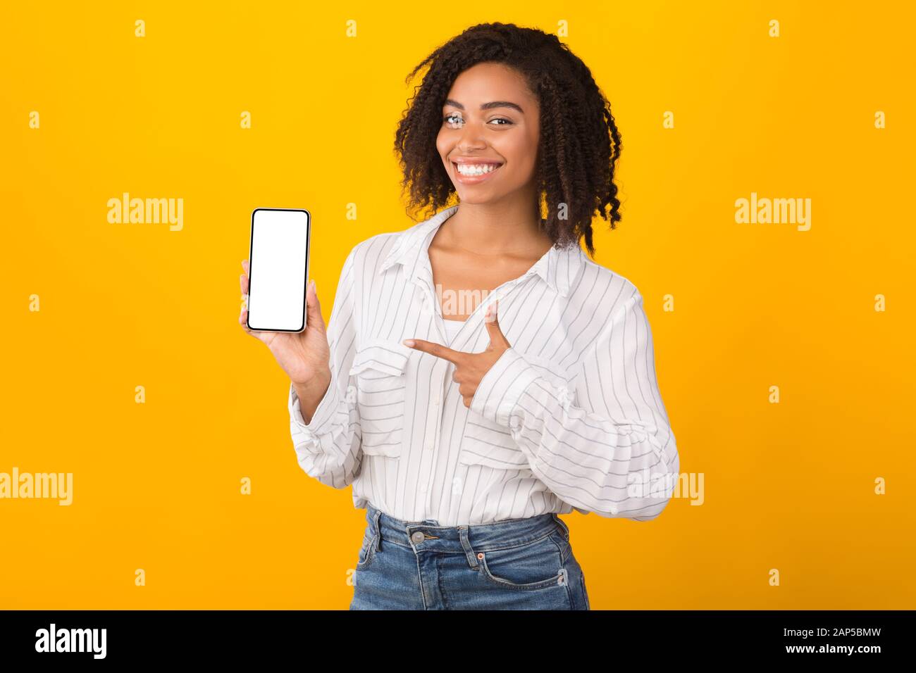 Donna afro sorridente che mostra una nuova app al telefono Foto Stock