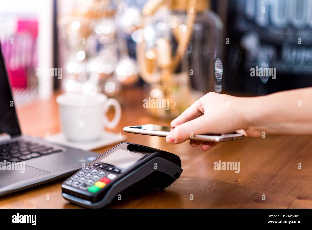 Donna che utilizza il terminale per il pagamento senza contatto tramite smartphone. Nuova tecnologia di pagamento NFC, pagamento tramite cellulare Foto Stock