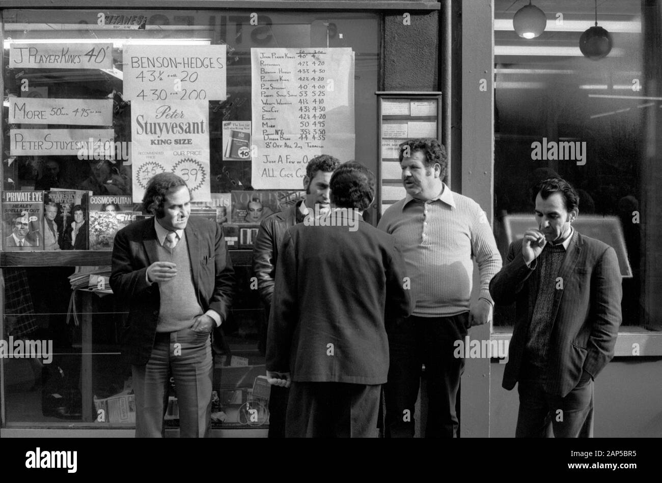 London 1970s uomo appeso di fronte alla corner shop newsagents e negozio generale. Strutton Ground Street Victoria 1976 Regno Unito HOMER SYKES Foto Stock