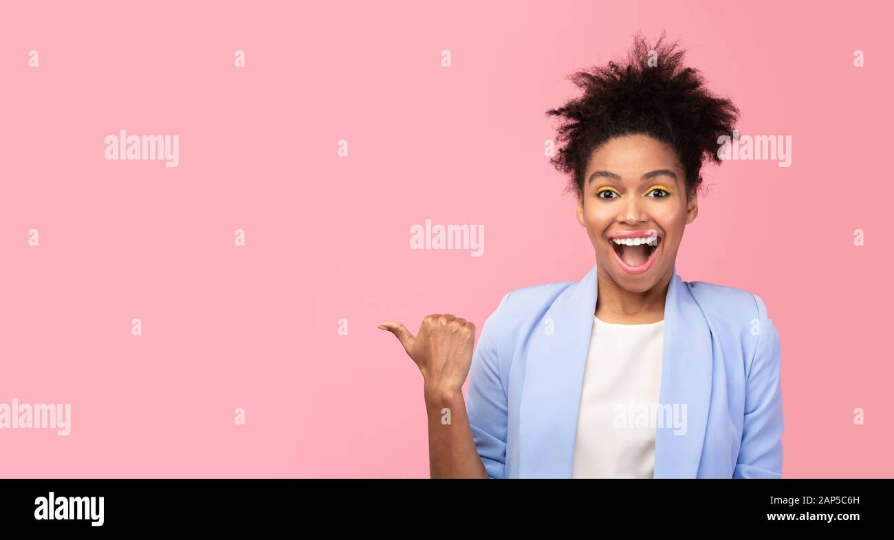 Donna nera eccitata che punta il dito sullo spazio libero Foto Stock