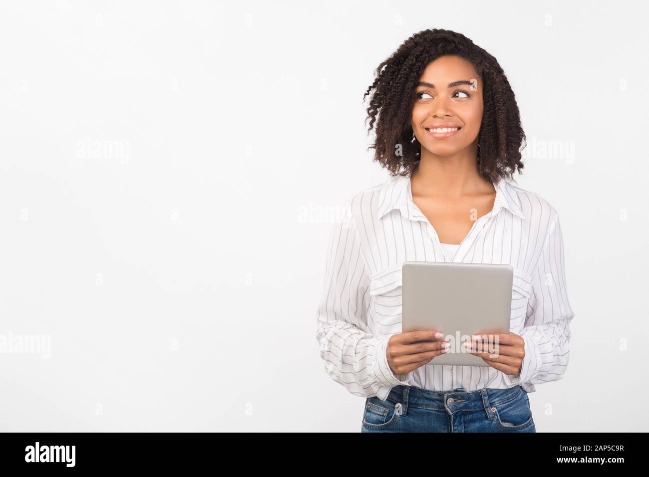 Afro donna con tablet che guarda spazio vuoto Foto Stock
