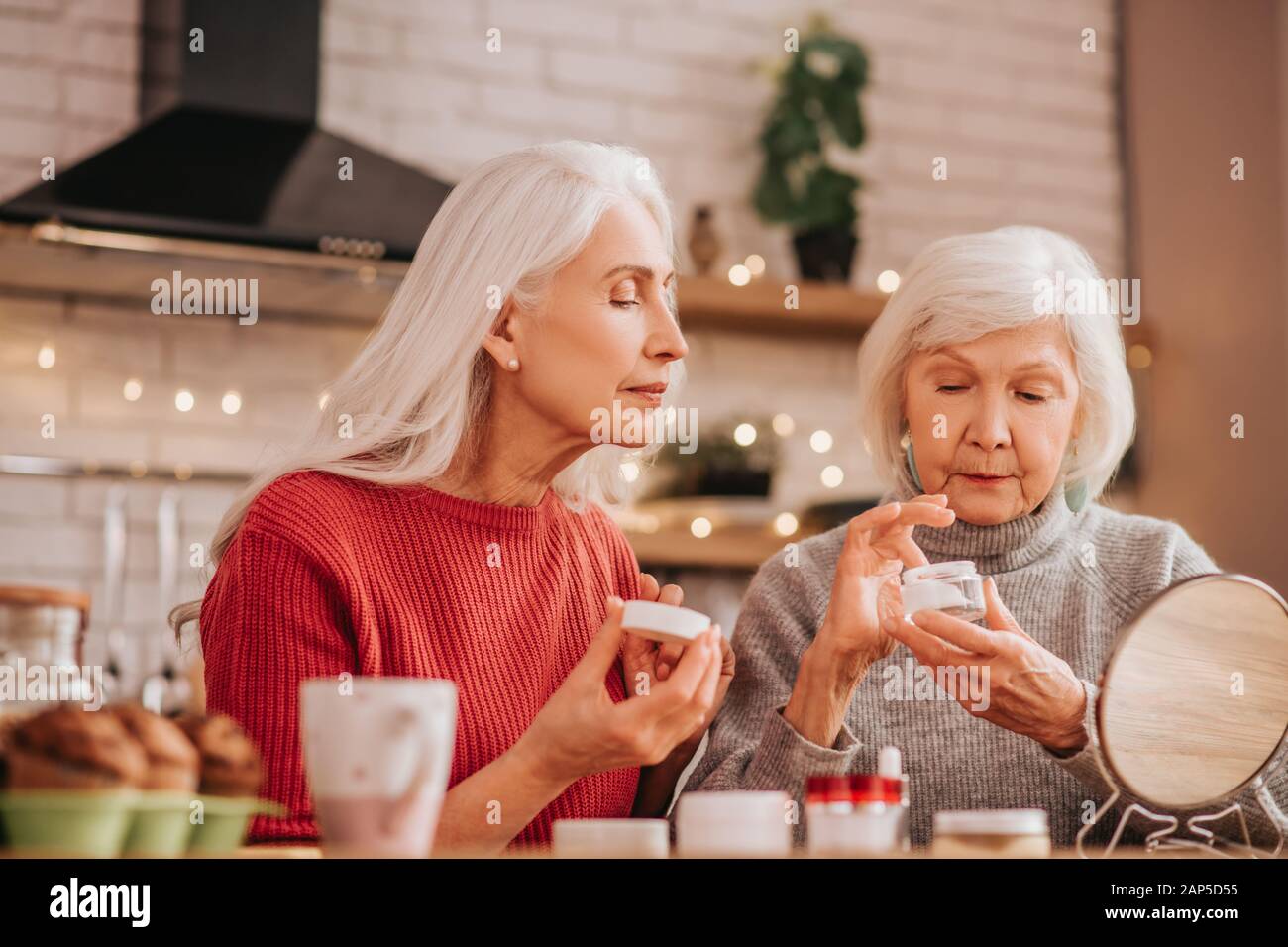 Due belle donne anziane di applicare la nuova crema Foto stock - Alamy