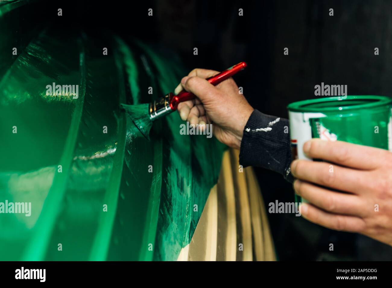 Dipingere una tradizionale barca di legno di colore verde Foto Stock