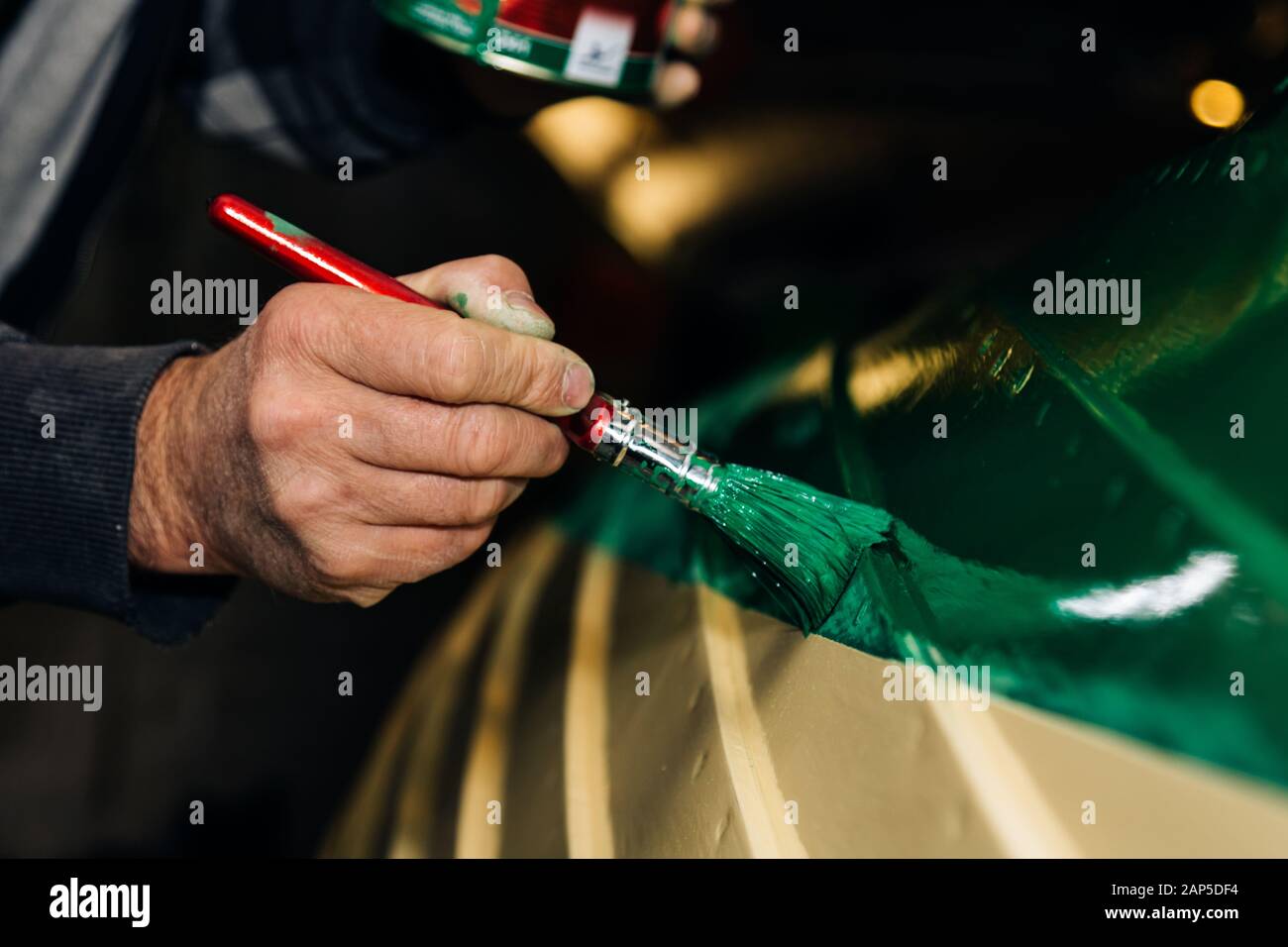 Dipingere una tradizionale barca di legno di colore verde Foto Stock
