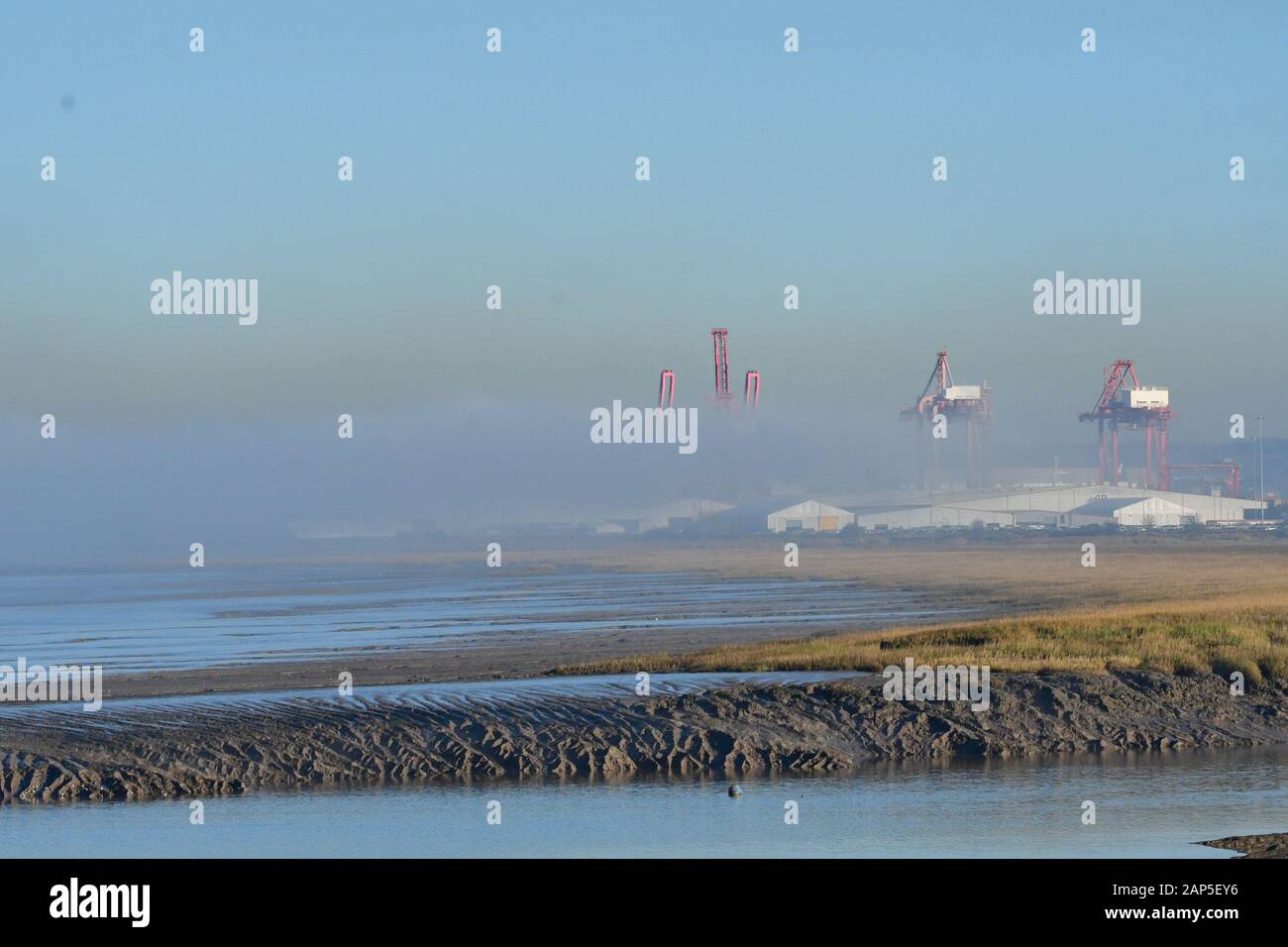 Bristol. Xxi Jan 2020. Regno Unito Meteo. Spesso la nebbia costiera arrivati molto presto questa mattina e ancora intorno al tardo pomeriggio nel canale in lingua inglese presso il Royal Portbury Dock. Dock gru laterale può essere visto sospesa nella nebbia e un mare navi può essere visto lasciare il porto passato turbine eoliche visto anche galleggiante nella fitta nebbia. Credito: Robert Timoney/Alamy Live News Foto Stock