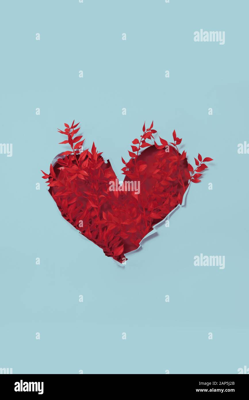 Valentine cuore rami rossi con foglie dipinte in carta buco Foto Stock