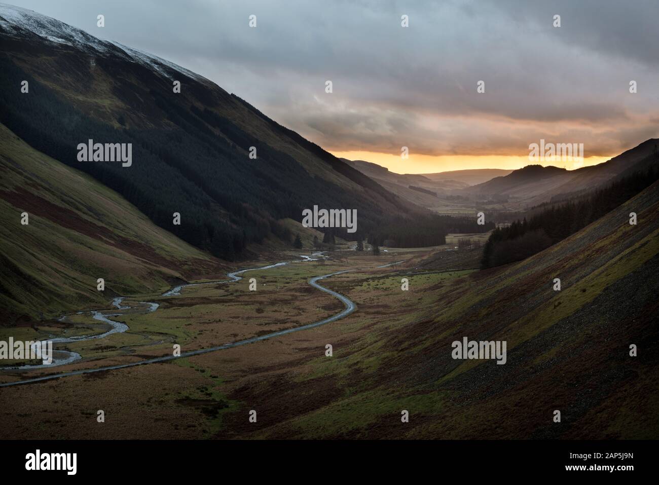 Tramonto sulla strada e il fiume di Moffat Acqua che si snoda attraverso Moffat Dale, Dumfries e Galloway Foto Stock