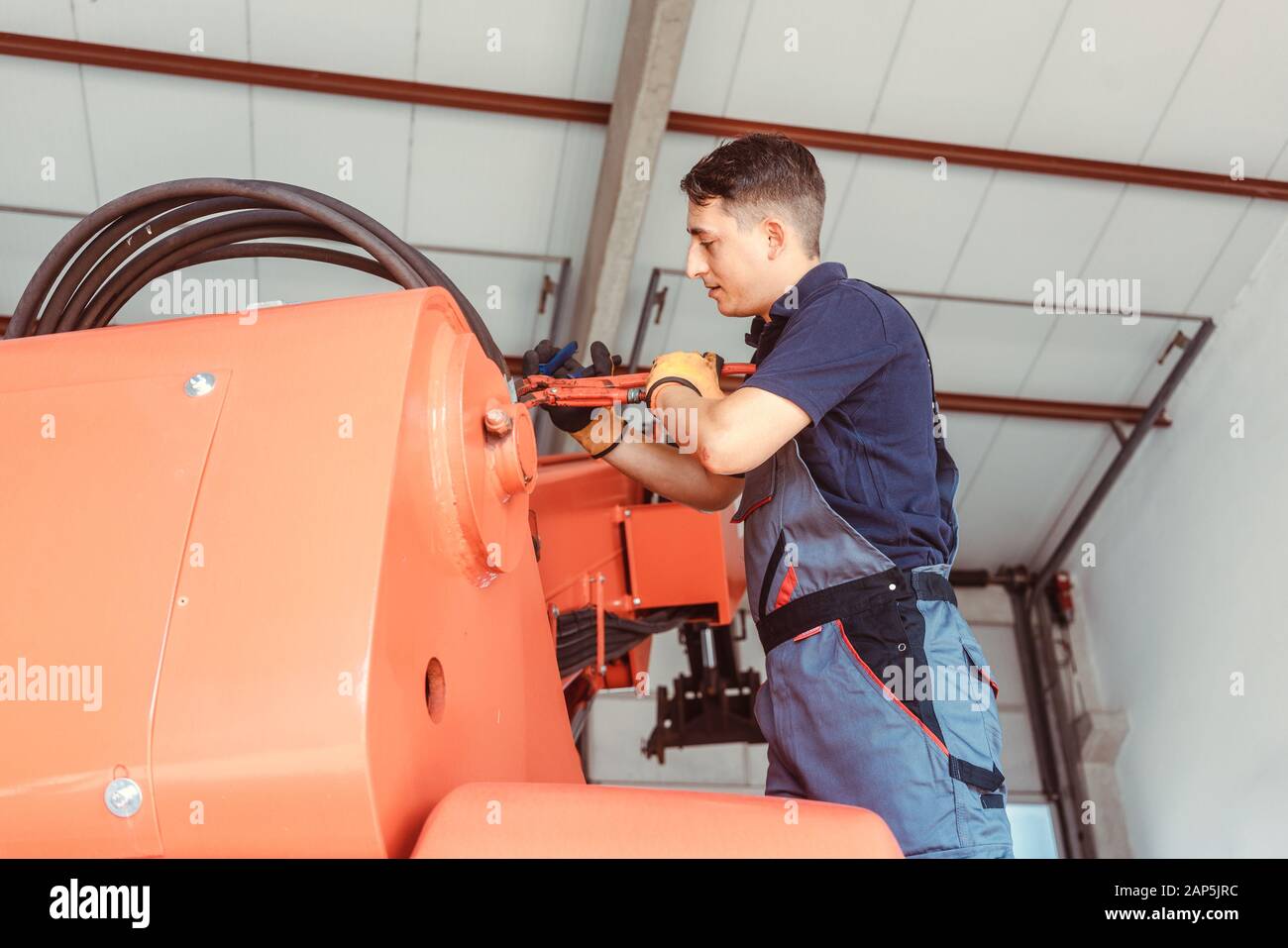 Il tecnico effettuando alcuni lavori di manutenzione sulla macchina agricola Foto Stock