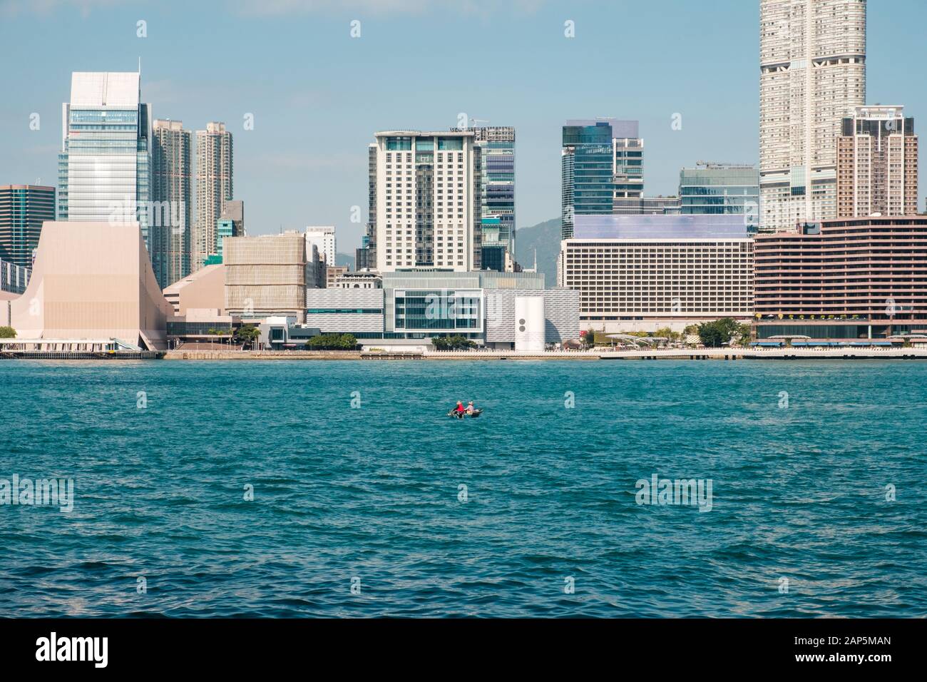 Hong Kong Cina - Novembre 2019: piccola barca sul Victoria Harbour con Skyline e la vista della costa di Hong Kong e Kowloon e Tsim Sha Tsui Foto Stock