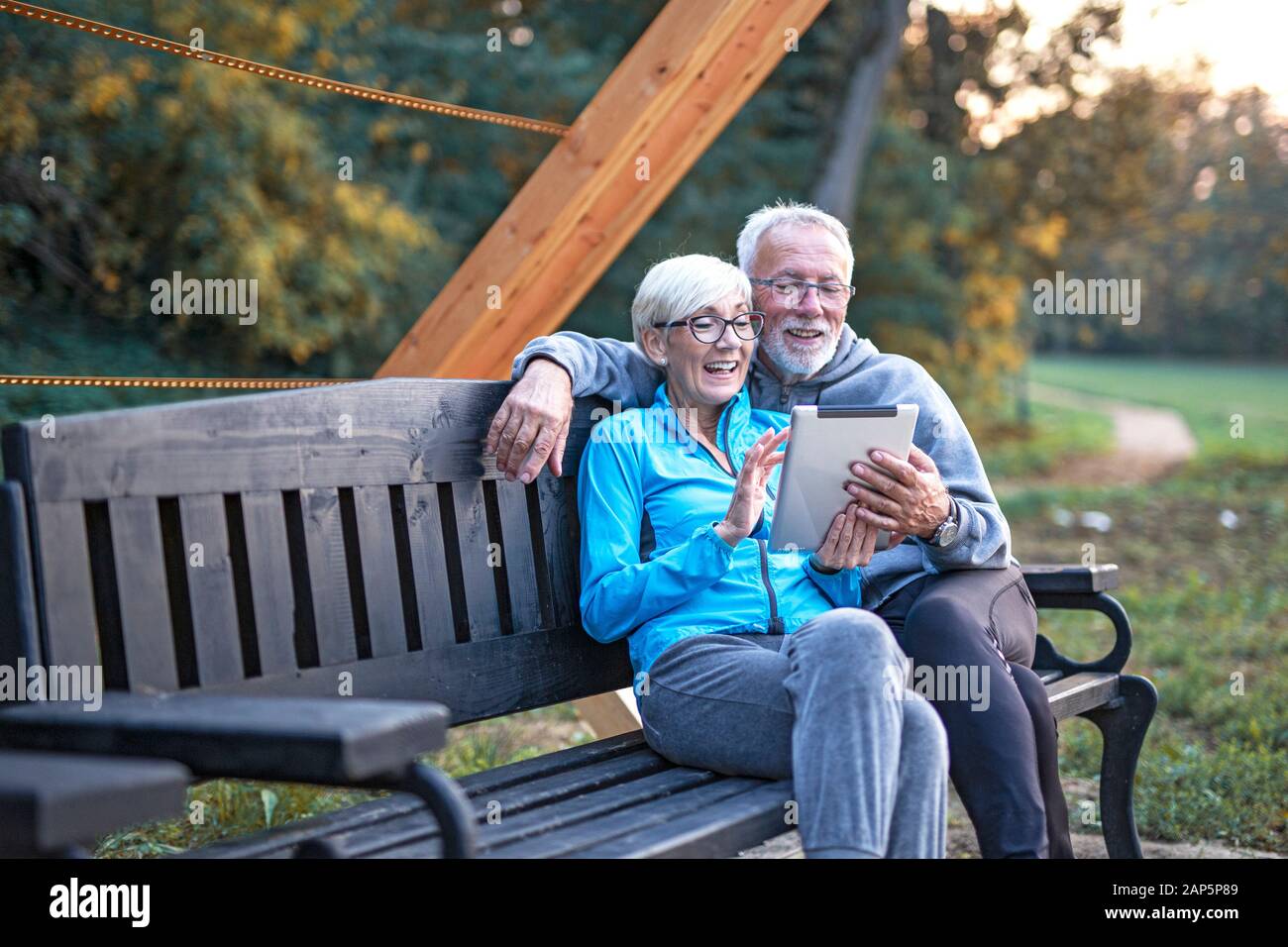 Sul banco vecchia coppia con tablet a portata di mano Foto Stock