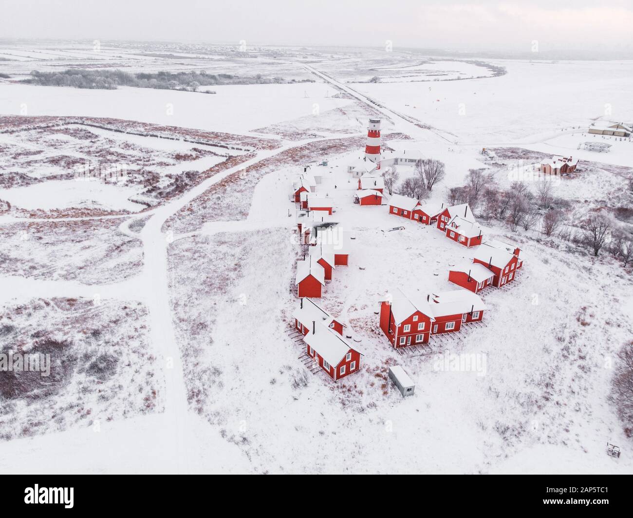 Vista panoramica dei colorati edifici in legno con vista dall'alto. Villaggio di pescatori e città turistica. Case rosse di legno del villaggio di pescatori in nevoso coperto in inverno. Foto Stock