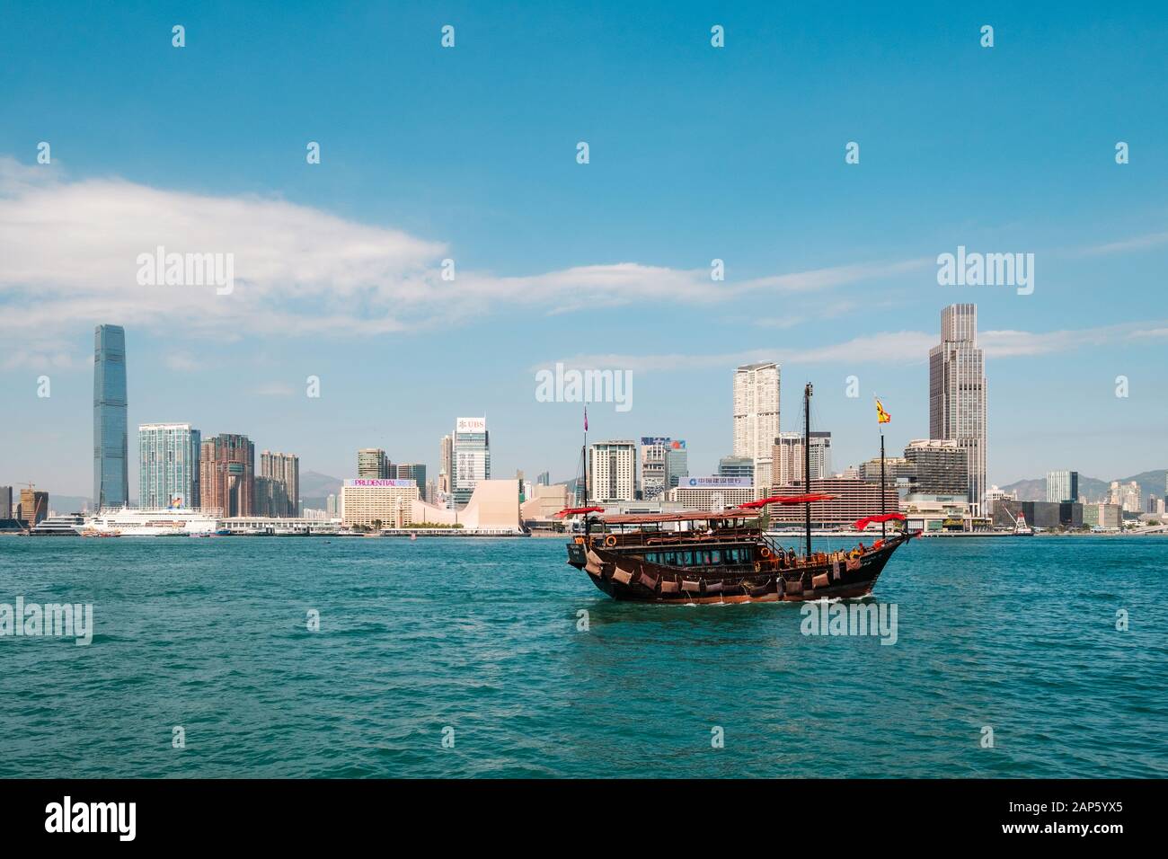 Hong Kong, Hong Kong - Novembre 2019: il vecchio legno barca a vela sul Victoria Harbour con skyline di Hong Kong / Kowloon city background Foto Stock