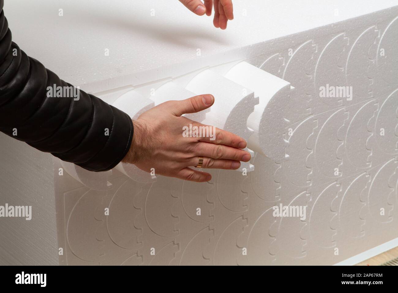 Piccola produzione privata per il taglio di prodotti e figure in schiuma su una macchina con riscaldamento elettrico. Produzione di isolamento per tubi Foto Stock