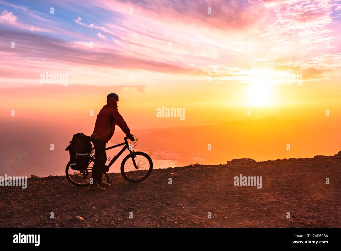 Mountain Bicycle rider con zaino viaggia su sfondo di sunrise, Lanzarote isole Canarie Foto Stock
