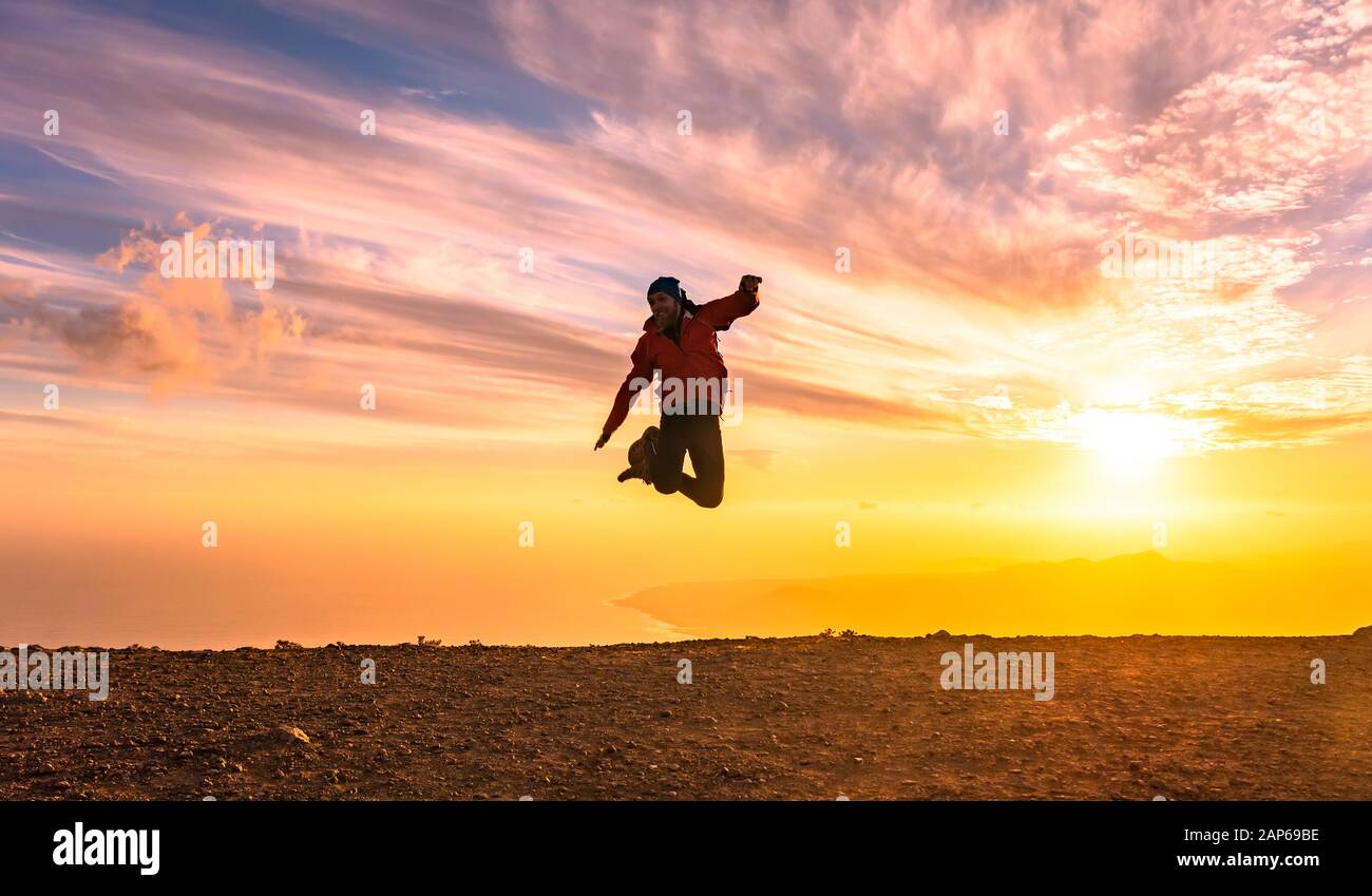 Uomo felice salti di gioia al tramonto. Il successo, vincitore, felicità, ttavel concetto. Foto Stock