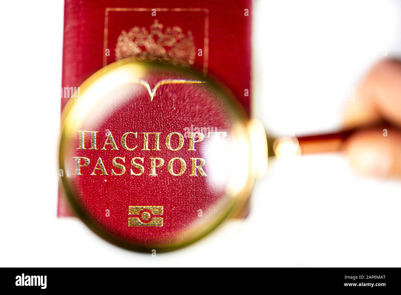 Passaporto russo sotto una lente di ingrandimento su sfondo bianco Foto Stock