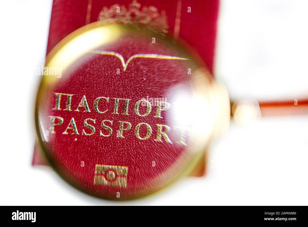 Passaporto russo sotto una lente di ingrandimento su sfondo bianco Foto Stock