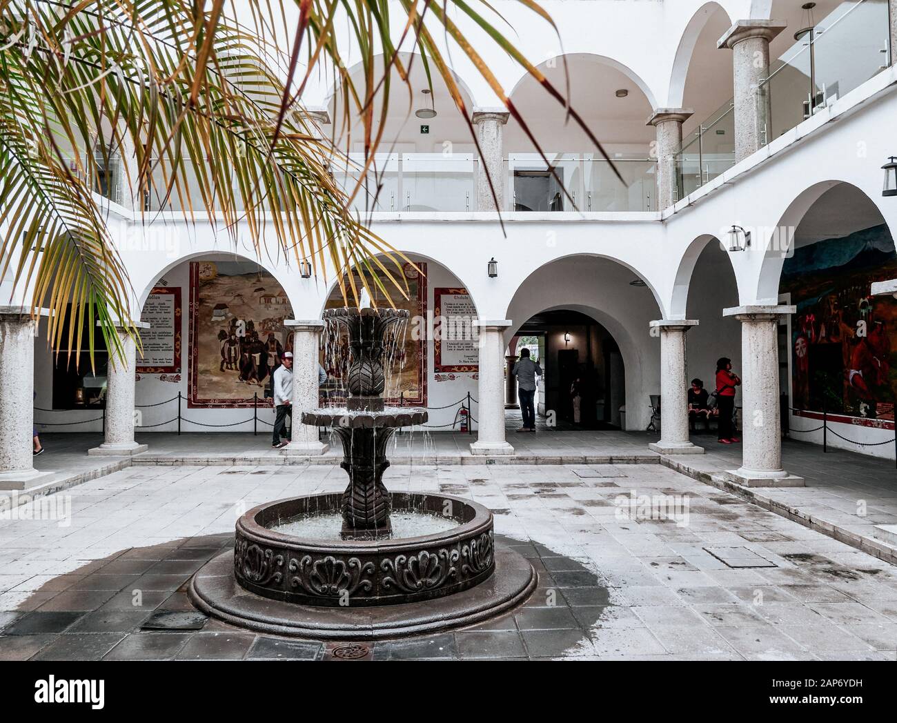 San Pedro Cholula, Messico, 17 ottobre 2018 - Colonnata con archi, fontana e palme nella piazza interna del municipio di San Pedro Cholula. Foto Stock