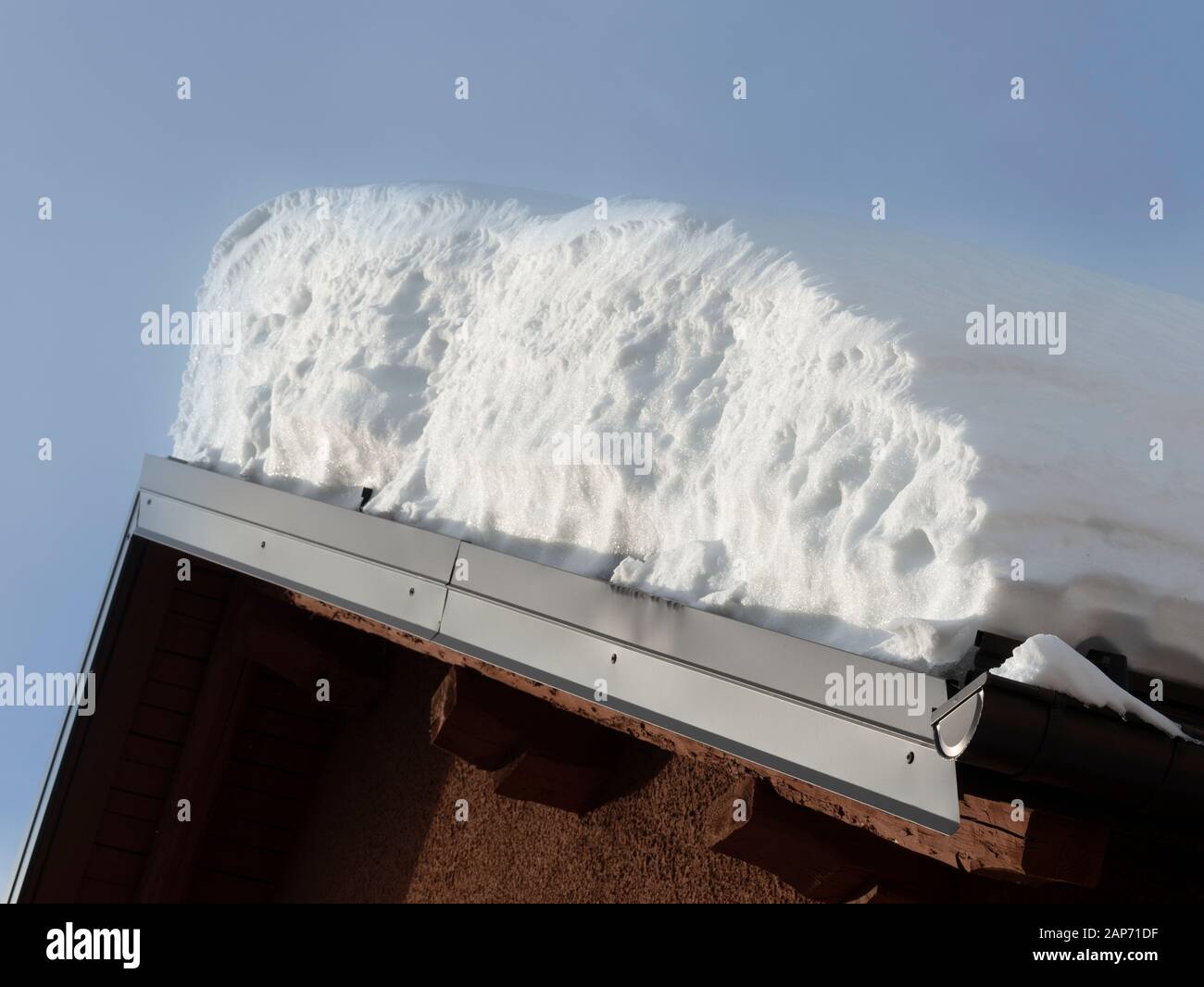 tetto passo di una casa di montagna con una grande quantità di neve Foto Stock