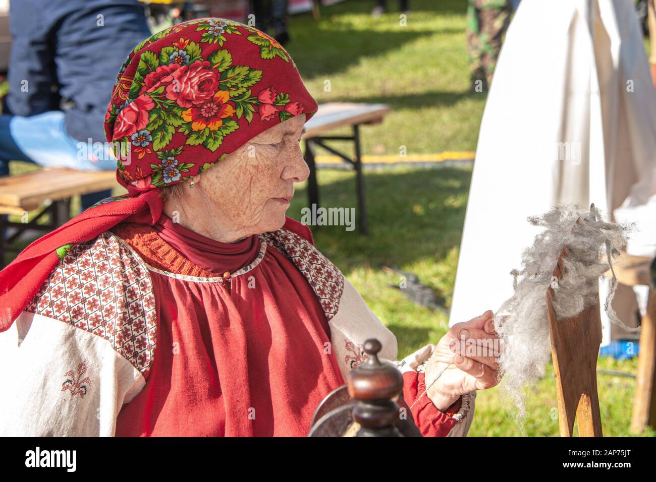 Izmailovsky Park, Mosca, Russia - 1 ottobre 2016: I discendenti di Cossack alla fiera e Cossack riunione. Una donna gira i fili su una vecchia filatura Foto Stock
