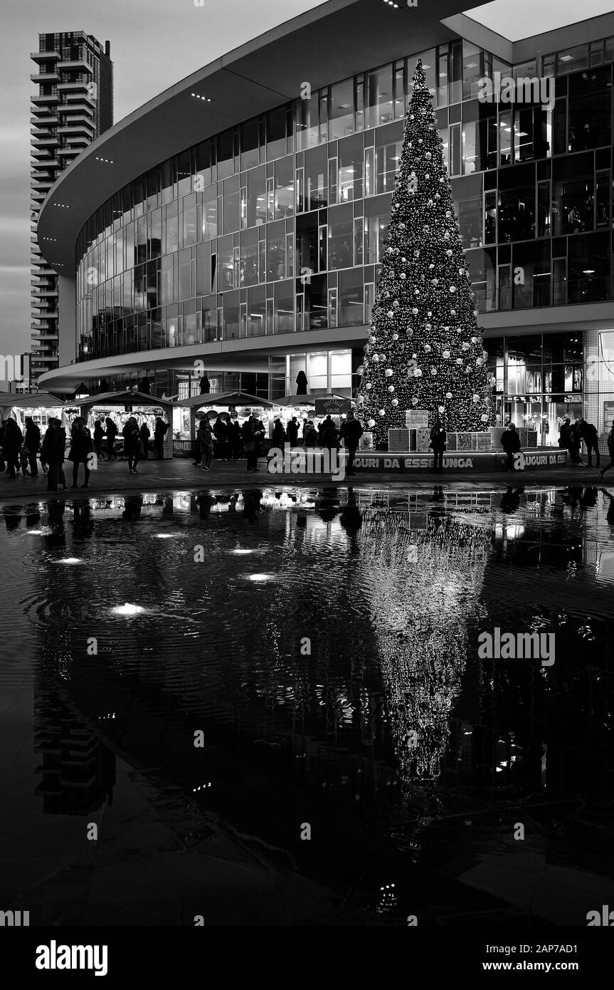 Albero di Natale e mercatino di natale in piazza Gae Aulenti con torre Solaria, gente e fontana - Milano, Italia Foto Stock