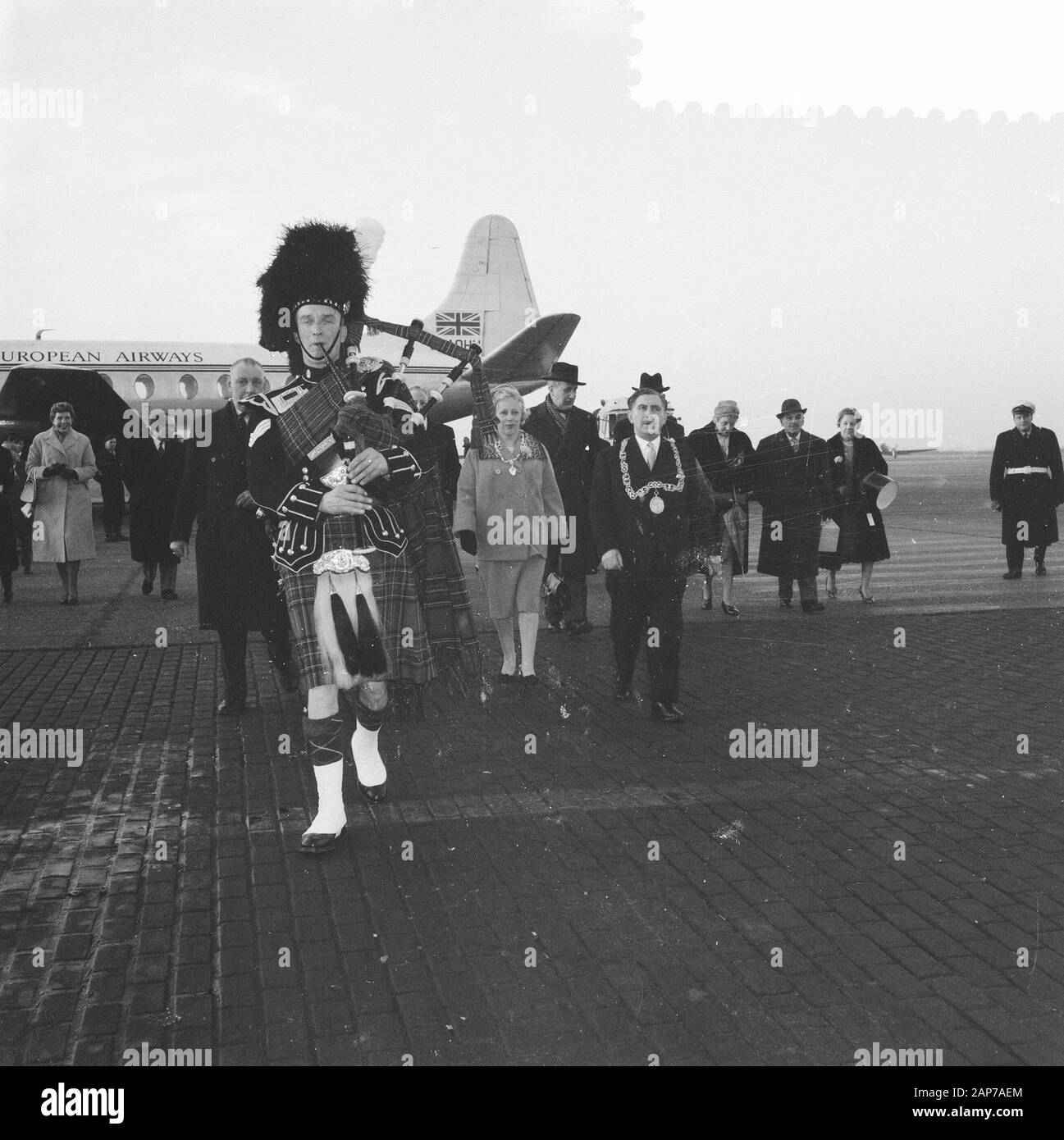 Arrivo Lord Provost di Glasgow all'aeroporto di Schiphol, l'azienda sulla strada per la sala di attesa nella parte anteriore di un lettore delle cornamuse Data: Dicembre 6, 1959 Parole chiave: arrivo, società, cornamuse giocatori nome personale: Lord Provost Foto Stock