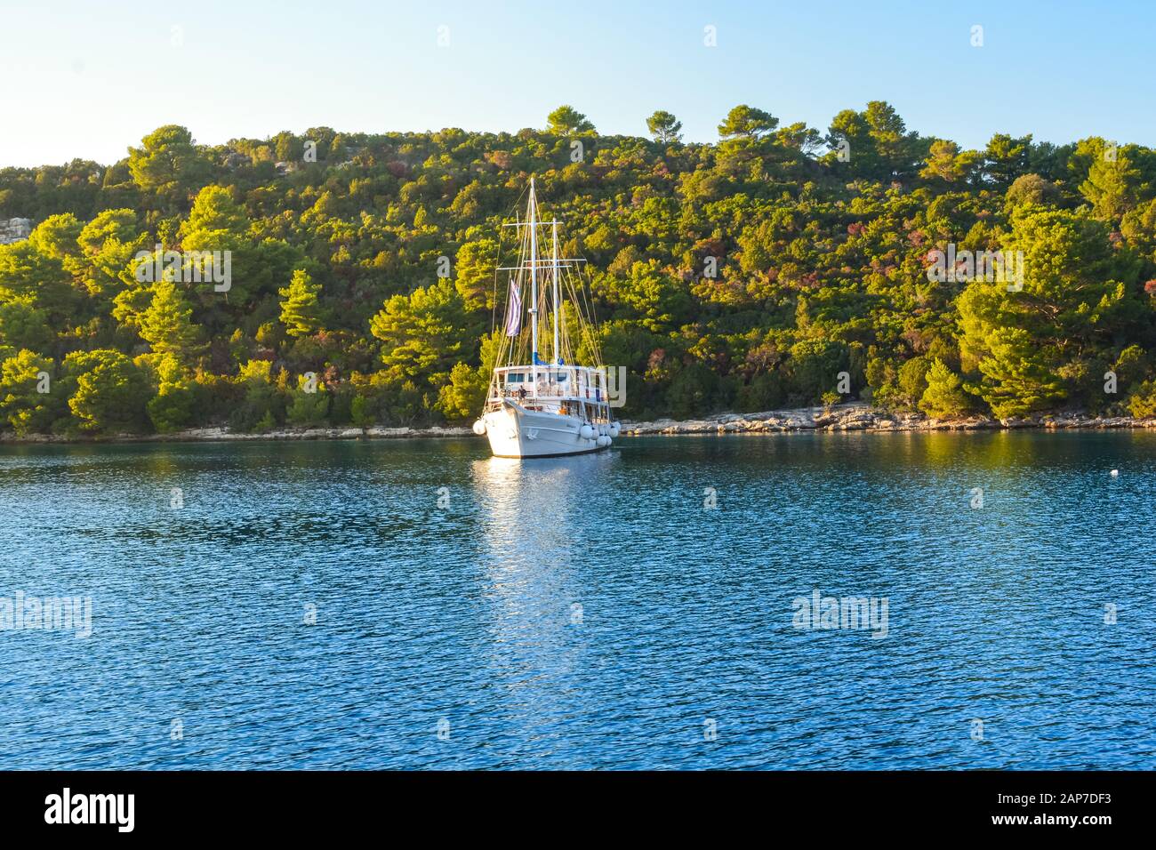 Una barca a vela gode di una soleggiata estate nel tardo pomeriggio lungo la costa dalmata della Croazia vicino Korcula Foto Stock