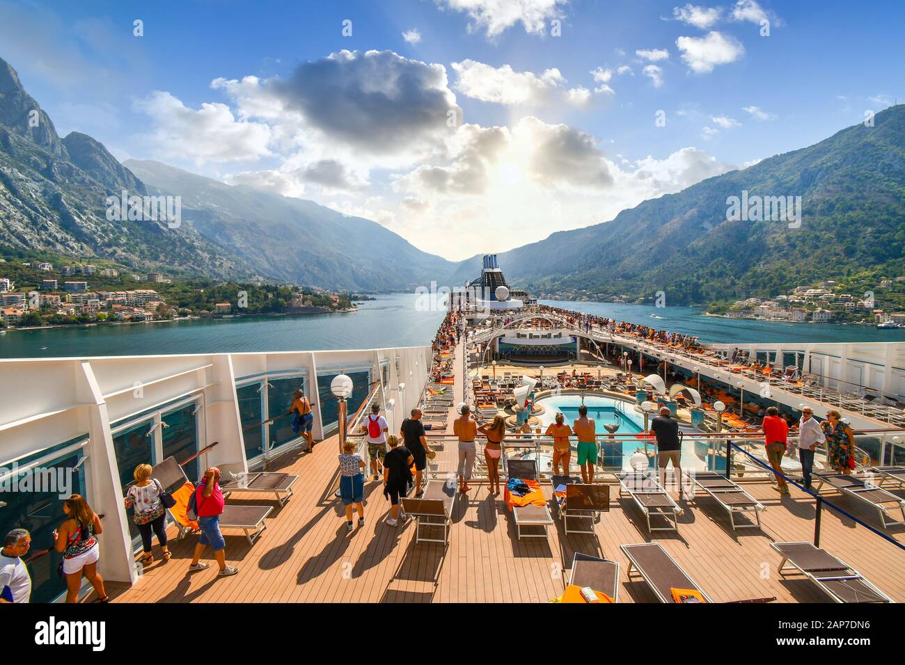I passeggeri a bordo del ponte superiore di una grande crociera sulla Baia di Cattaro, o Boka, si avvicinano al porto Adriatico di Cattaro, Montenegro Foto Stock