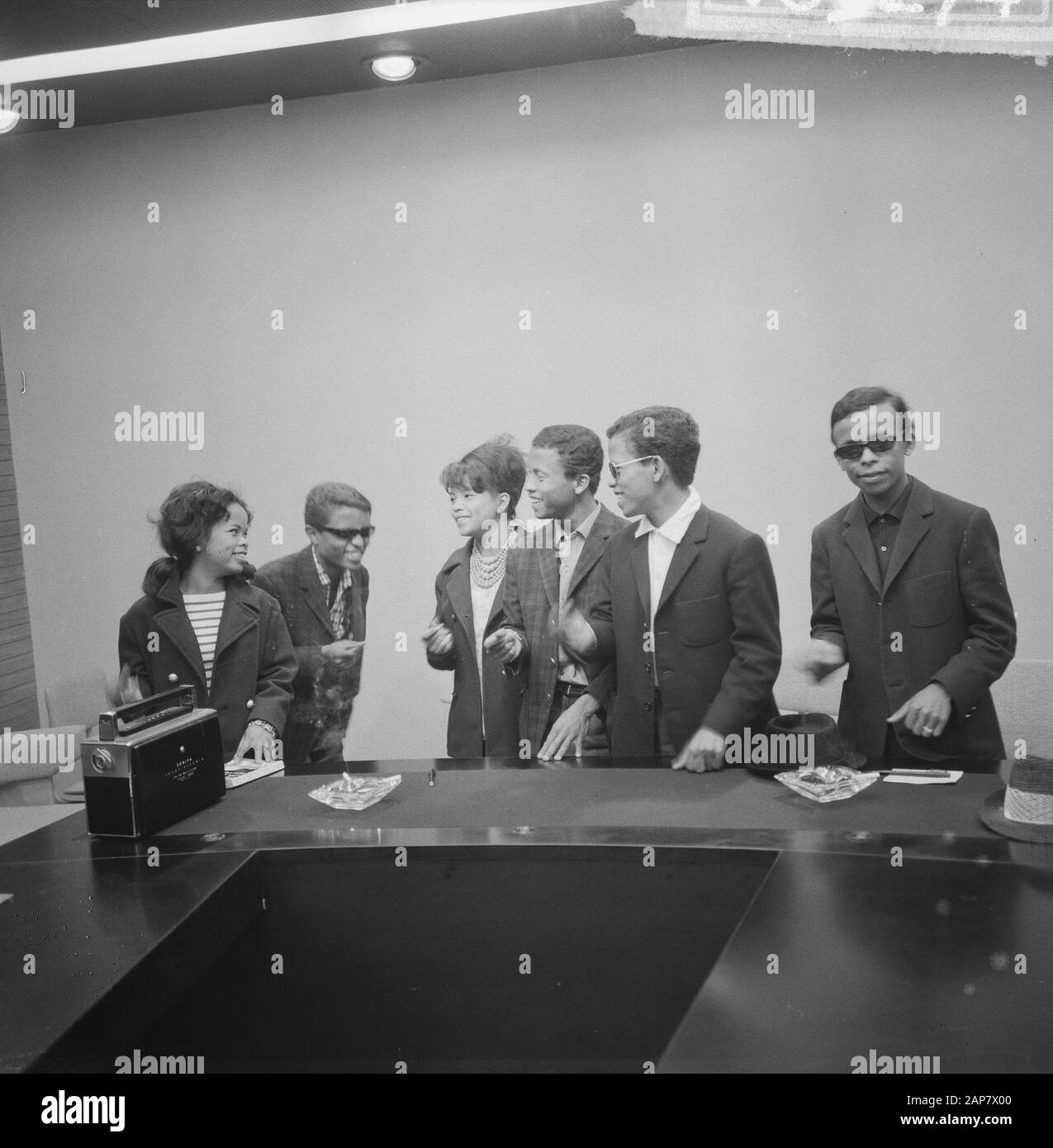 Arrivo gruppo di canto francese Les Surfs a Schiphol, nella sala stampa hanno portato un campione di tempo taglio con le dita Data: 8 giugno 1964 Località: Noord-Holland, Schiphol Parole Chiave: Arrivi, gruppi vocali Foto Stock