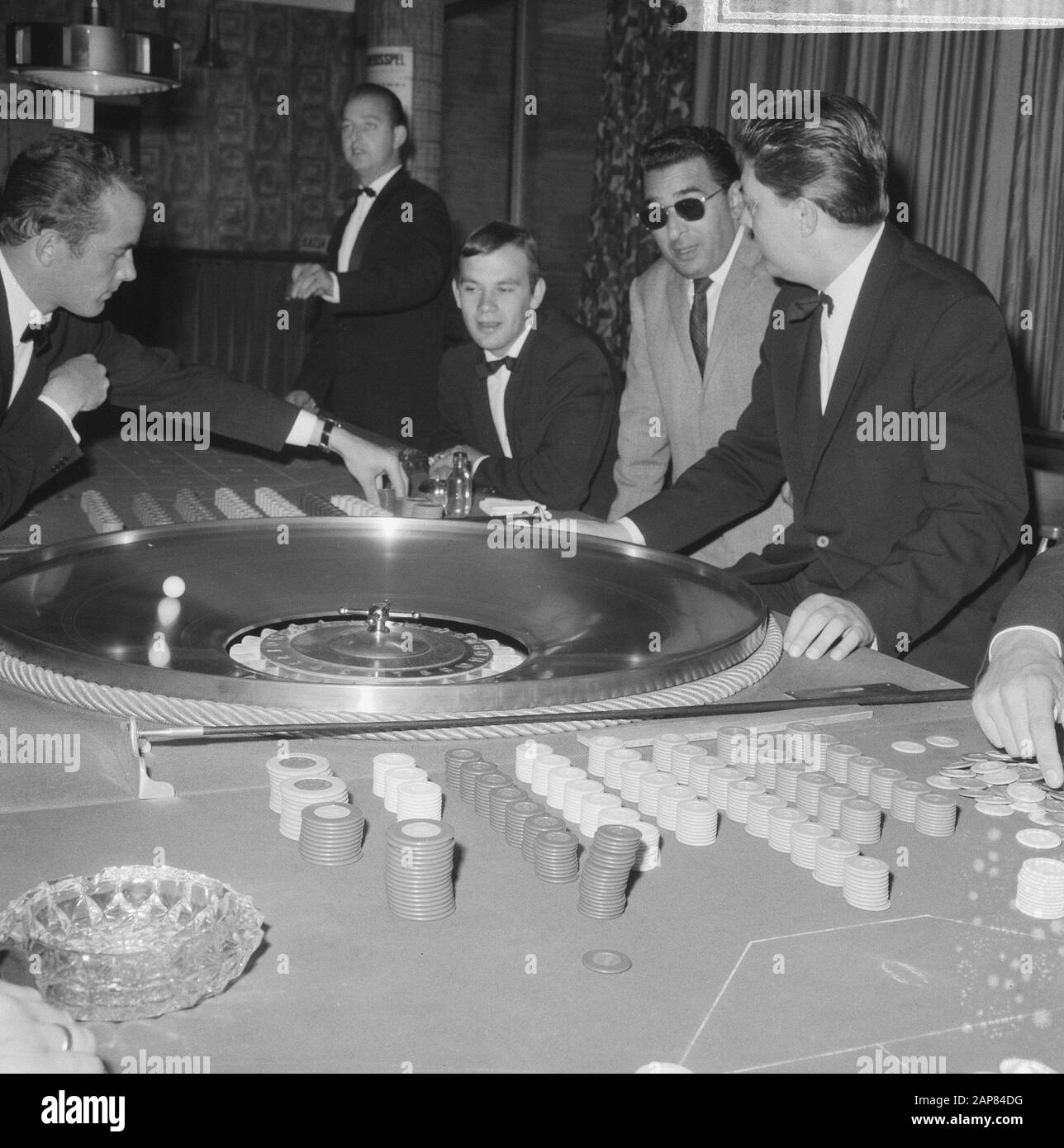 A seguito di una decisione del Ministero della Giustizia, i casinò dei Paesi Bassi devono chiudere le loro porte. In West-End to Loosdrecht oggi rotola la palla Descrizione: Visitatori mentre giocano alla roulette Data: 21 Ottobre 1965 Località: Loosdrecht, Noord-Holland Parole Chiave: Casinò, giochi d'azzardo Foto Stock