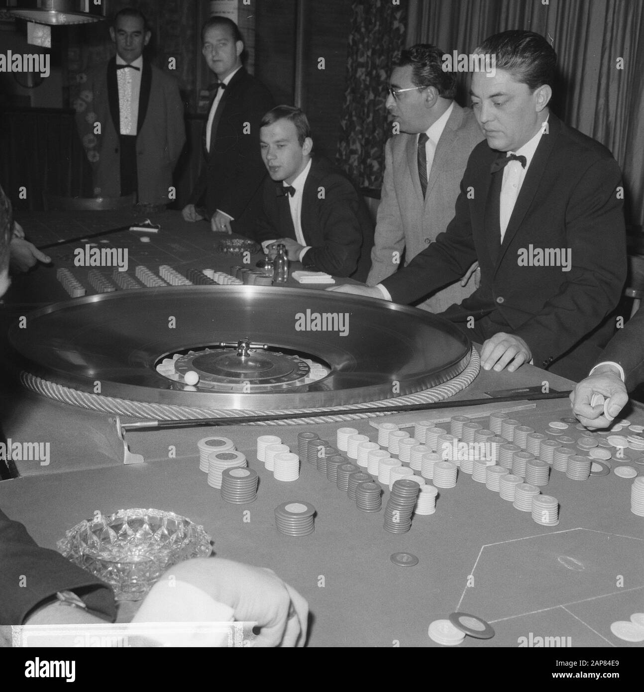 A seguito di una decisione del Ministero della Giustizia, i casinò dei Paesi Bassi devono chiudere le loro porte. In West-End to Loosdrecht oggi rotola la palla Descrizione: Visitatori mentre giocano alla roulette Data: 21 Ottobre 1965 Località: Loosdrecht, Noord-Holland Parole Chiave: Casinò, giochi d'azzardo Foto Stock